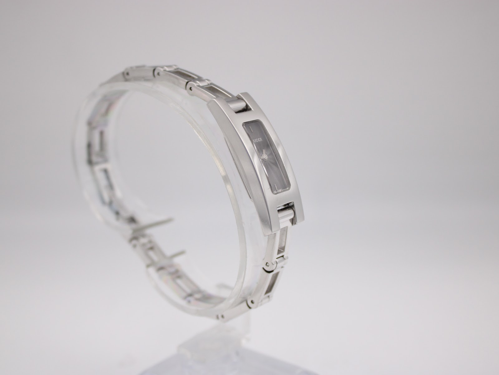 Angled view of the Gucci 3900L watch, showcasing the reflective black dial and polished stainless steel finish.