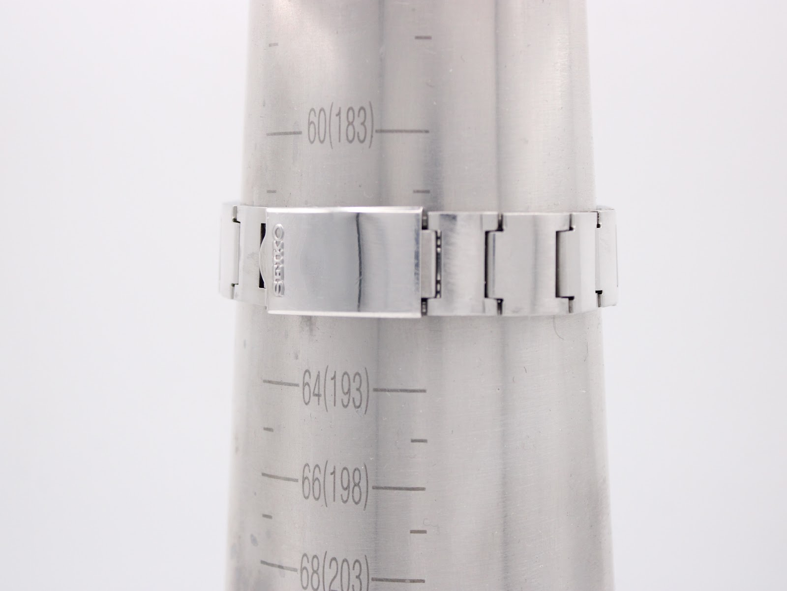 The Seiko watch bracelet measured on a wrist sizing gauge, indicating a wrist circumference of 183mm or 18.3cm. The clasp is visible and signed 'SEIKO'.