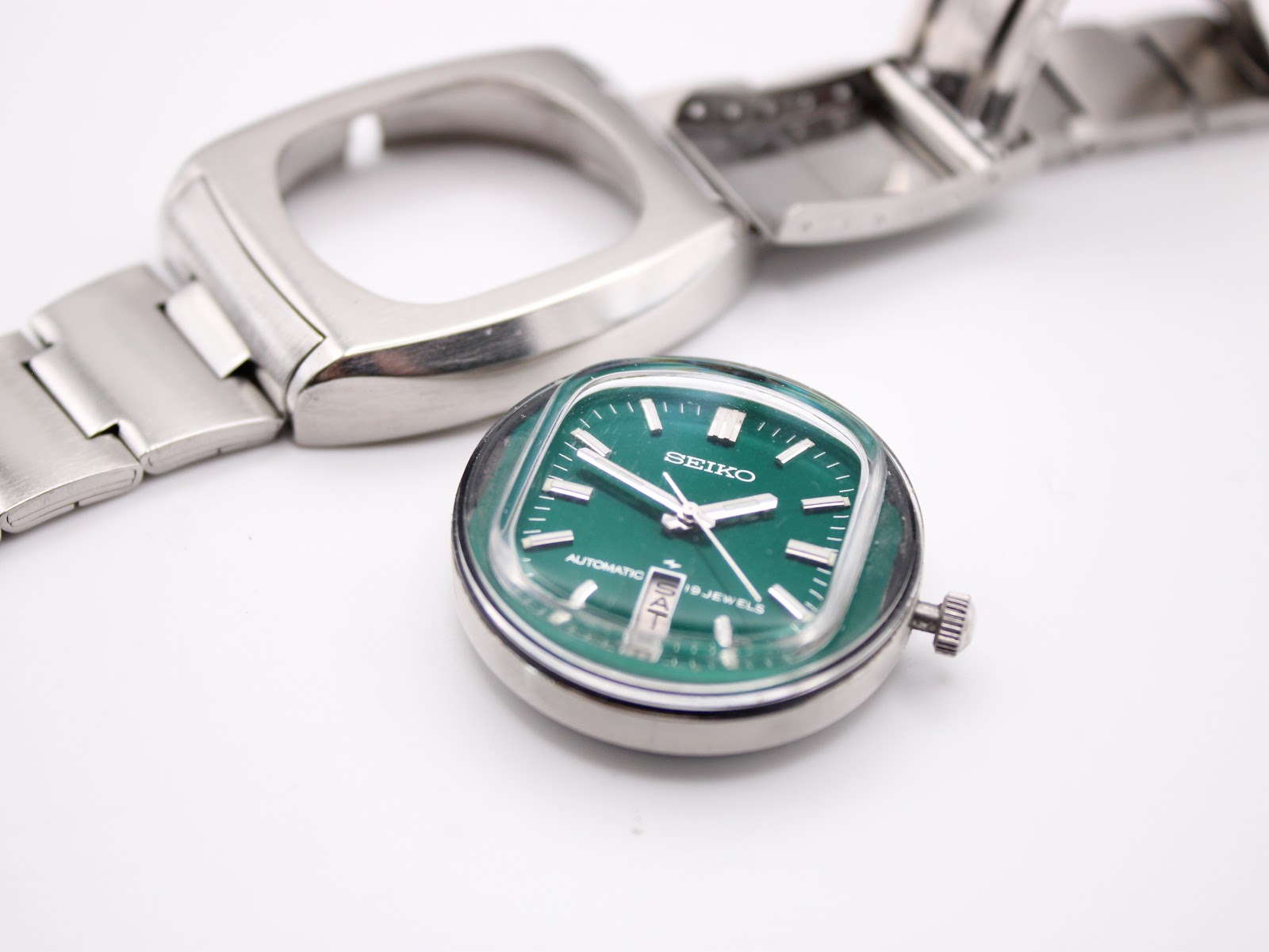 Disassembled view of the Seiko 7006-5070, showing the green dial and movement module separated from the outer rectangular case.