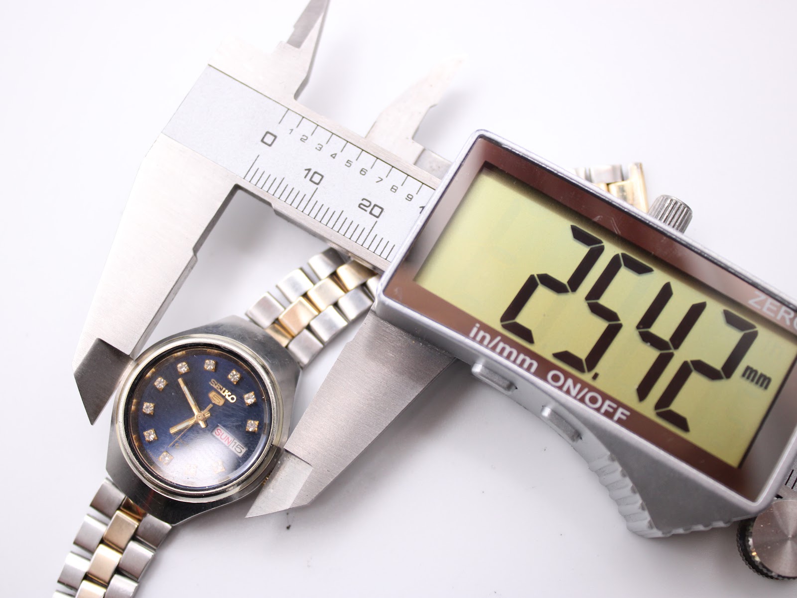 Digital caliper measuring the case diameter of the Seiko watch, displaying 25.42 mm.