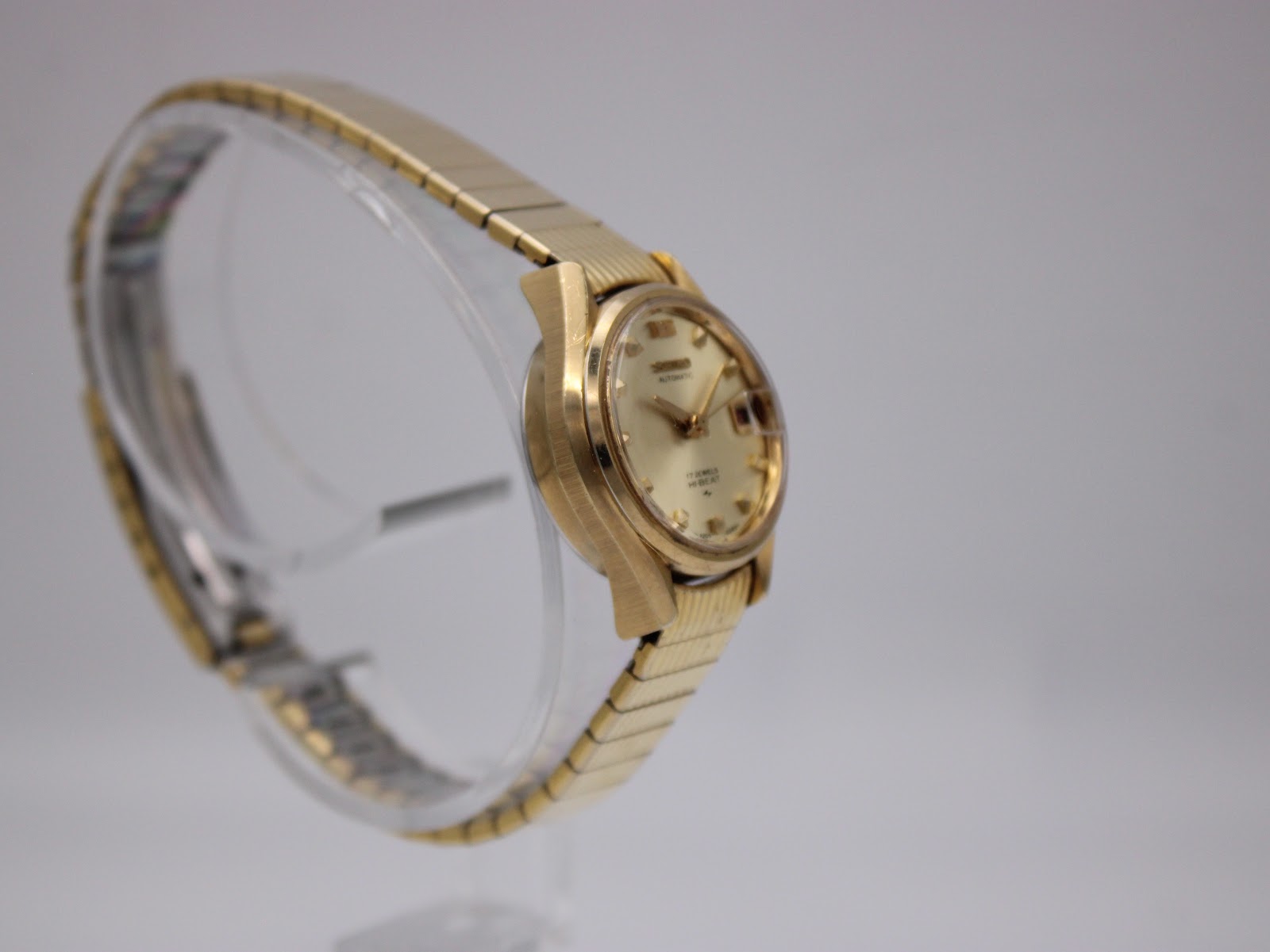 Another side view of the gold-tone Seiko automatic watch, highlighting the case shape and expanding bracelet.