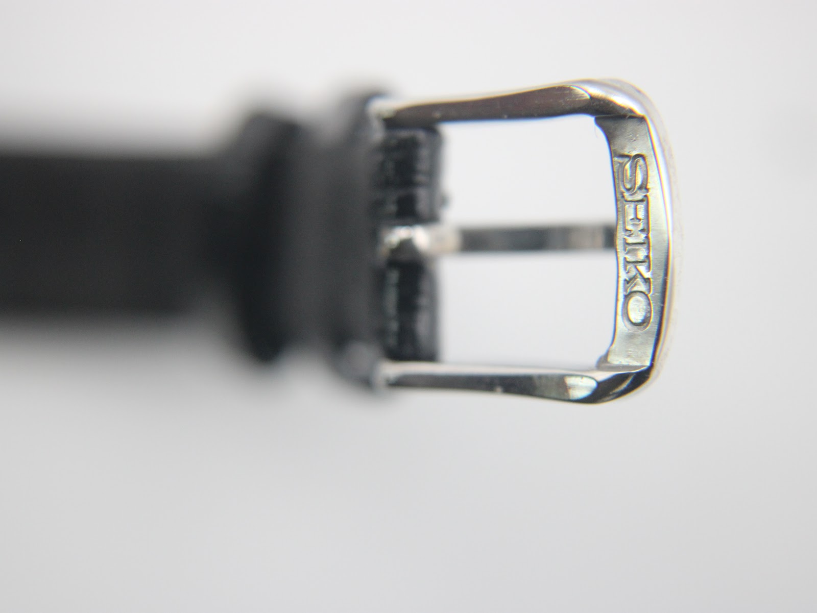 Close-up of the polished silver-tone pin buckle, engraved with "SEIKO".