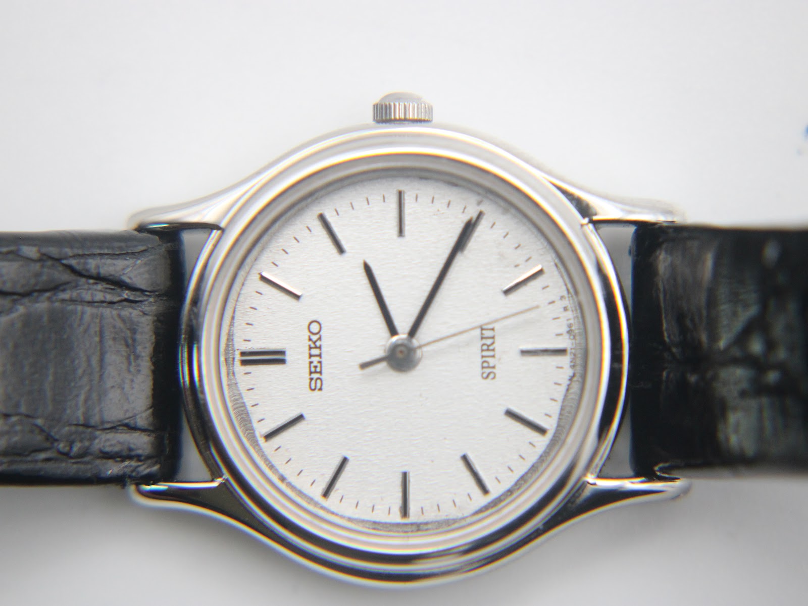 Detailed close-up of the Seiko Spirit white dial, showing applied silver baton indices and black hands.