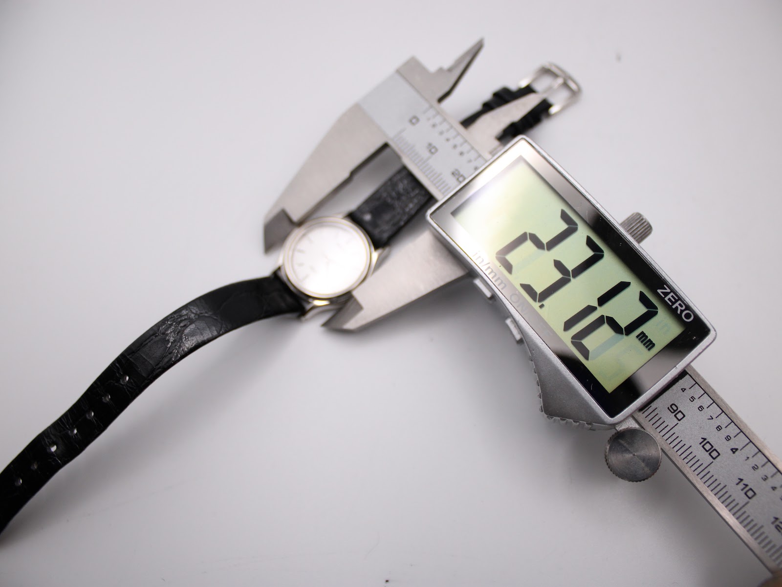 Digital caliper measuring the case diameter of the Seiko Spirit watch, displaying 23.12 mm.