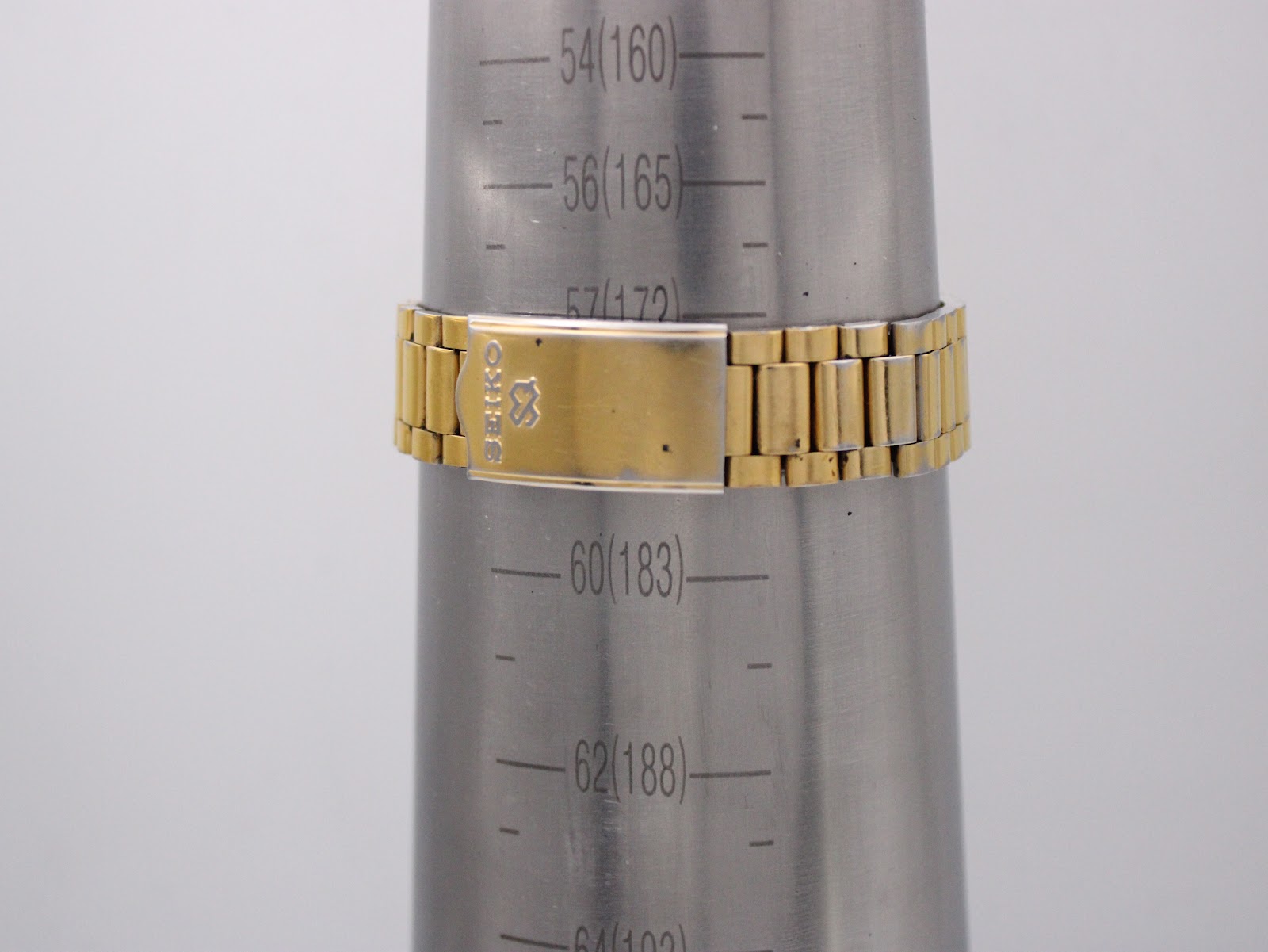 Close-up of the gold-tone steel bracelet clasp on a wrist sizing gauge, showing "Seiko" signed clasp and a wrist circumference of 17.2cm.