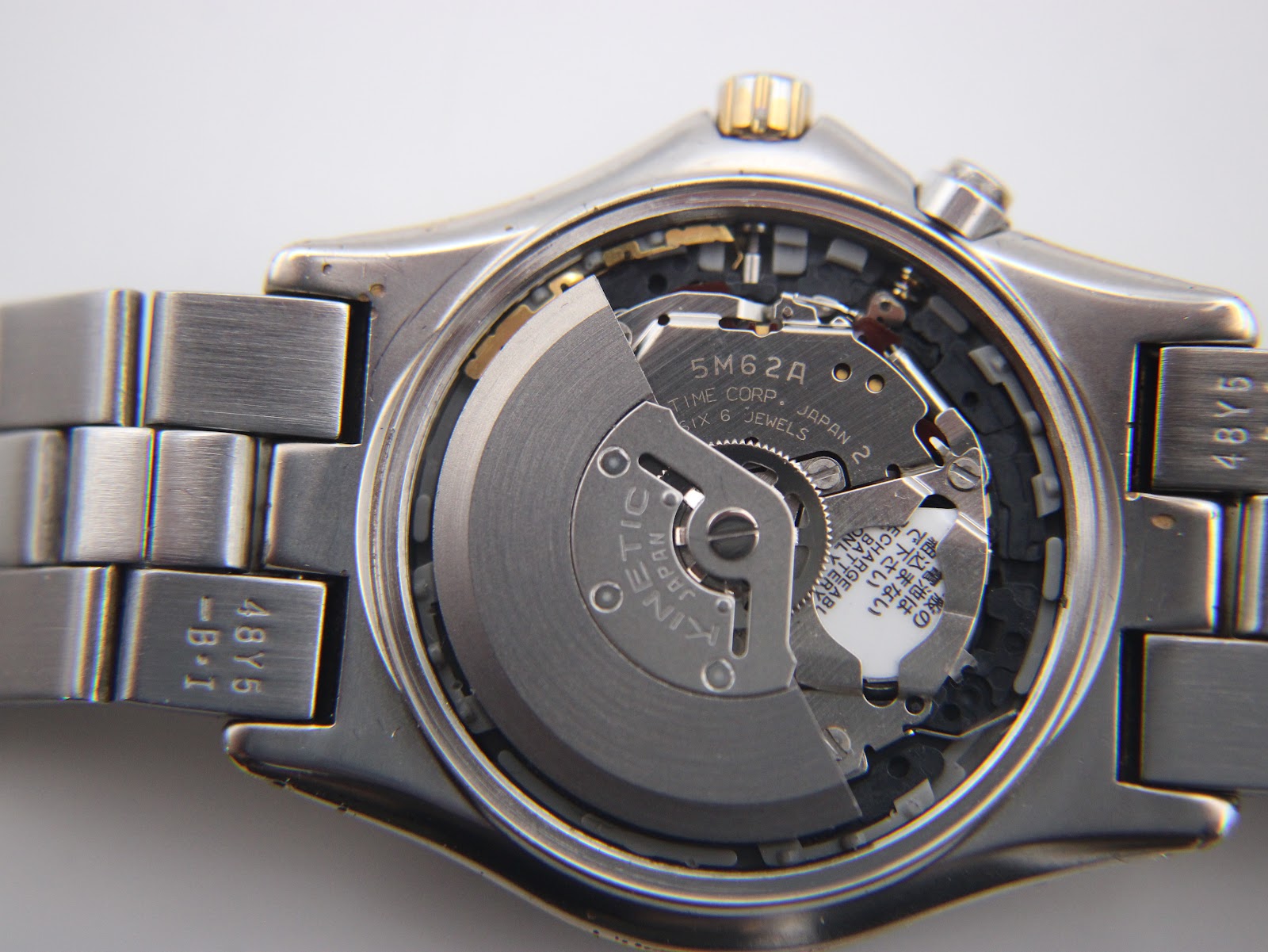 Close-up view of the Seiko 5M62A Kinetic movement inside the watch, showing the oscillating weight, 'TIME CORP, JAPAN 2', and '6 JEWELS' markings.