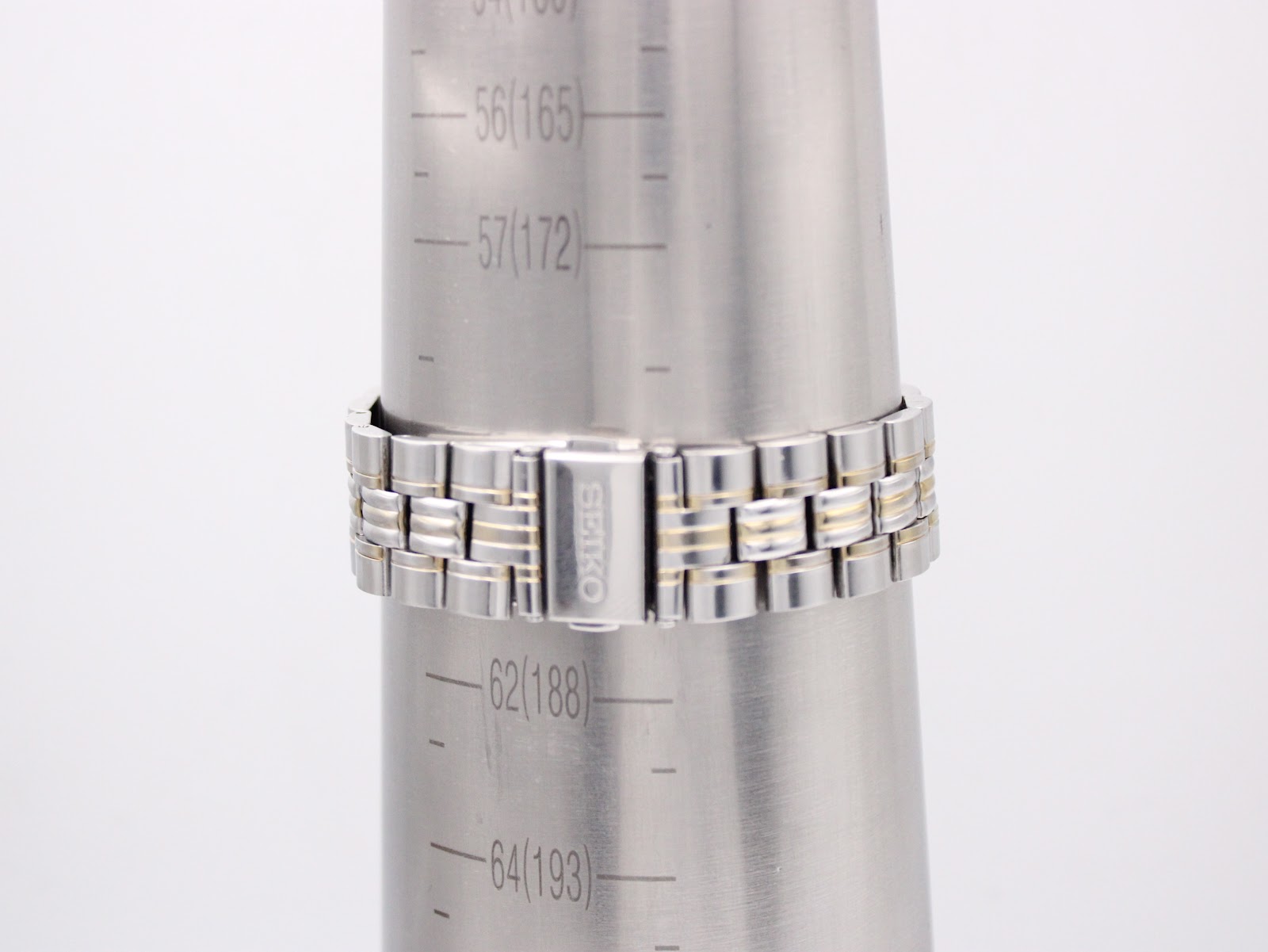 Close-up of the two-tone stainless steel bracelet wrapped around a wrist sizing gauge, showing a measurement of 188mm.