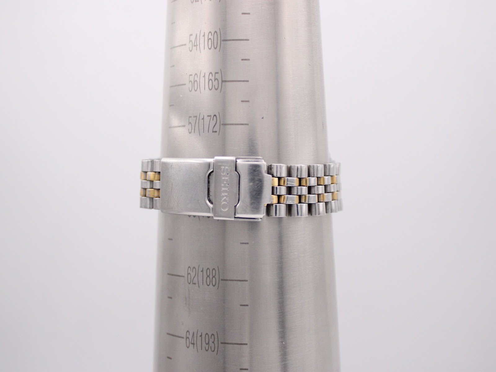 The two-tone Seiko steel bracelet and signed fold-over clasp on a wrist sizing cone, showing a wrist circumference of 188mm.