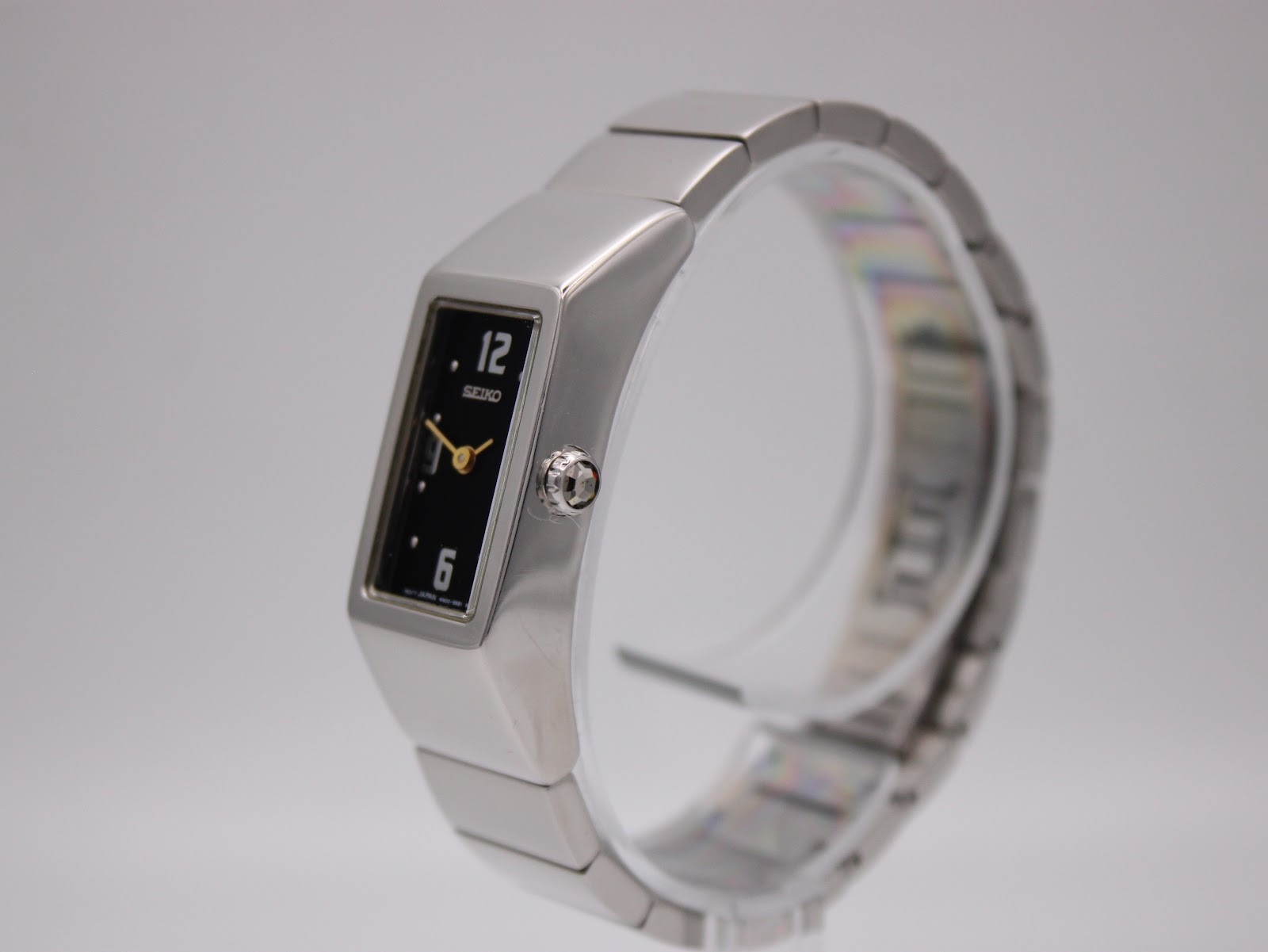 Angled front-right view of the Seiko watch on a display stand, showcasing the polished stainless steel case and crown.