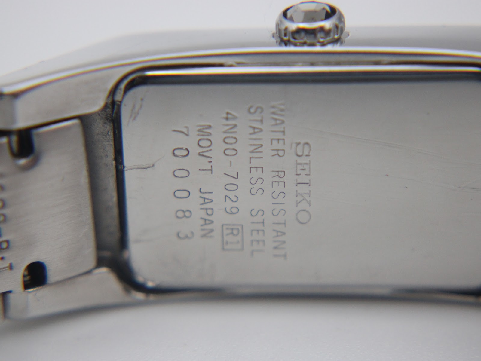 Close-up of the watch case back engraving, showing 'SEIKO WATER RESISTANT STAINLESS STEEL 4N00-7029 MOV'T JAPAN 700083'.