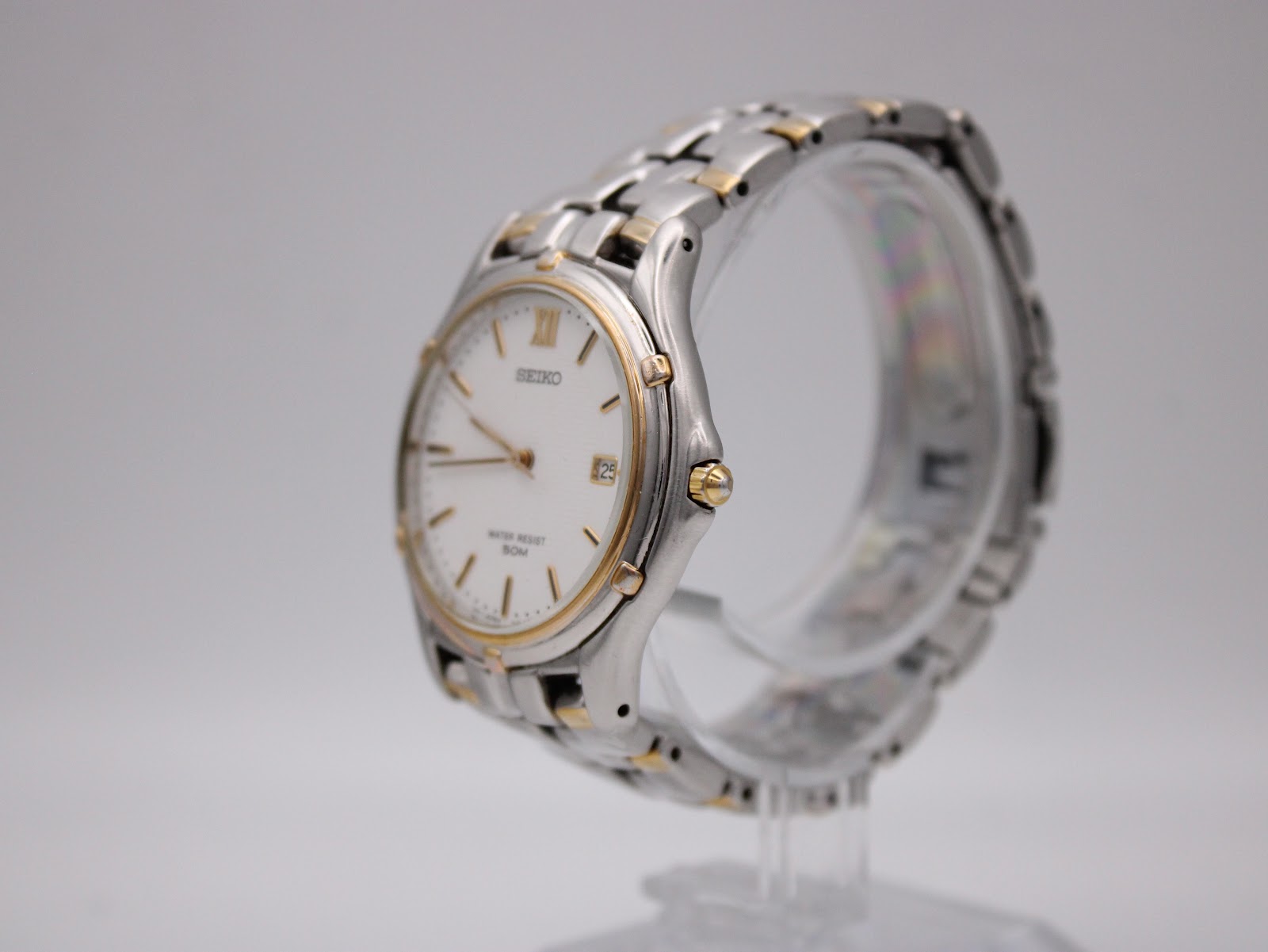 Angled left side view of the Seiko watch, showcasing the two-tone bracelet and case profile.