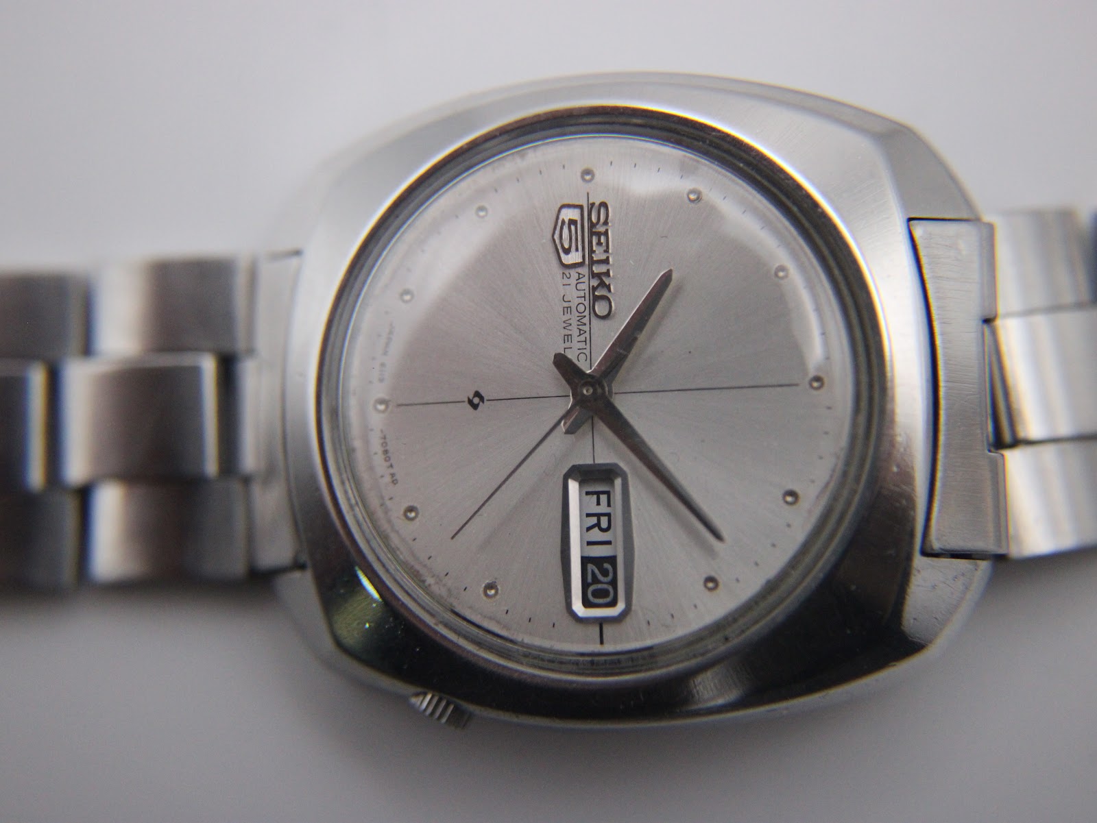 Close-up of the vintage Seiko's silver sunburst dial, displaying applied indices, hands, and the day-date window.