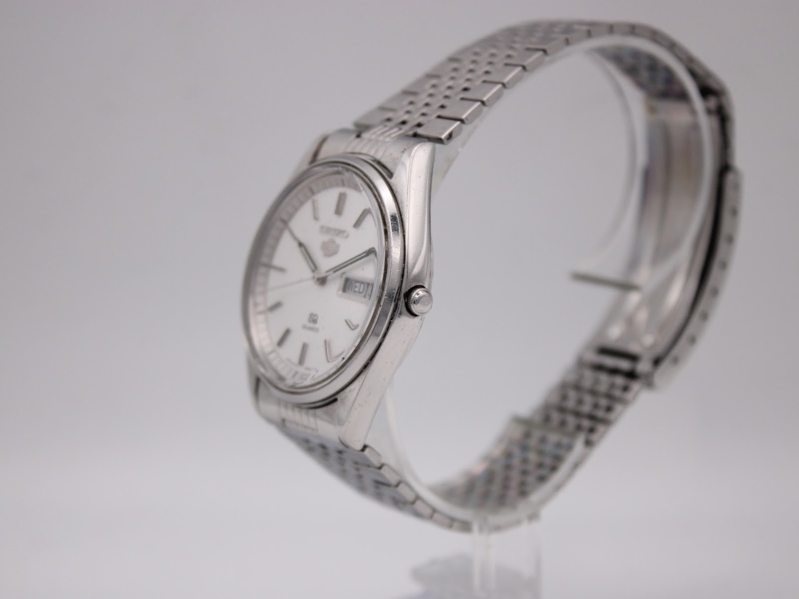 Angled side view of Seiko 8223-8080 showing the slim case, crown, and integrated brick-link stainless steel bracelet.