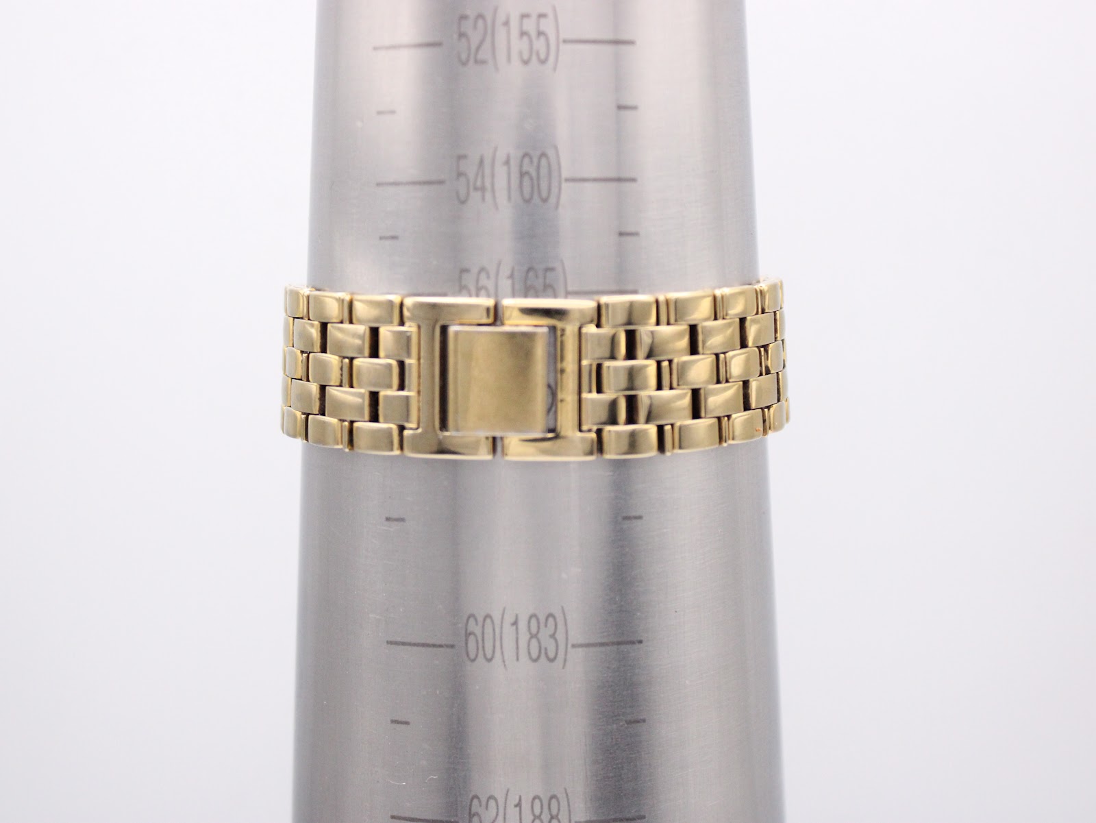 Close-up of the integrated gold-tone bracelet on a wrist sizing gauge, showing a wrist size of approximately 16.5cm.