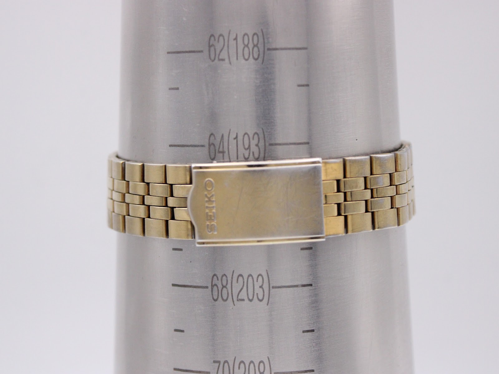 The integrated gold-tone bracelet of the Seiko watch displayed on a wrist sizing gauge, indicating a maximum fit of 193mm.