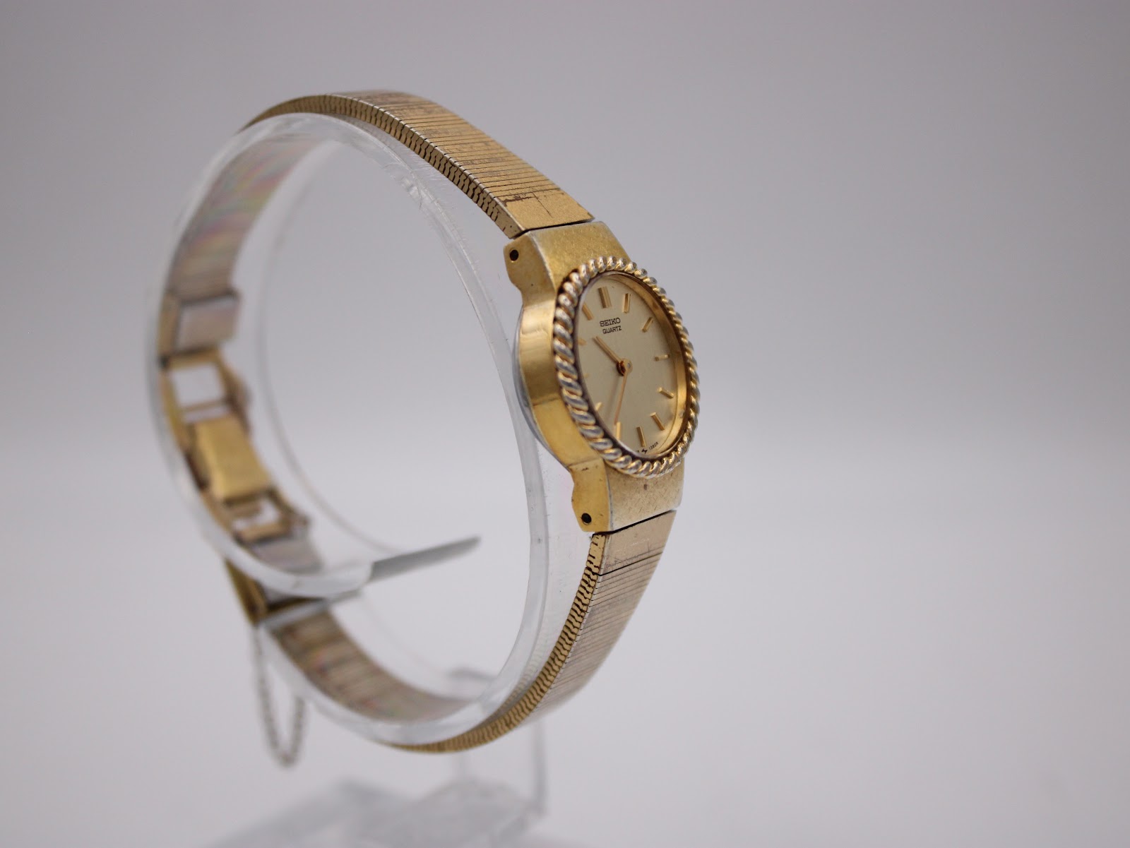 Angled side view of the Seiko watch on a clear stand, highlighting the unique rope bezel and integrated bracelet design.