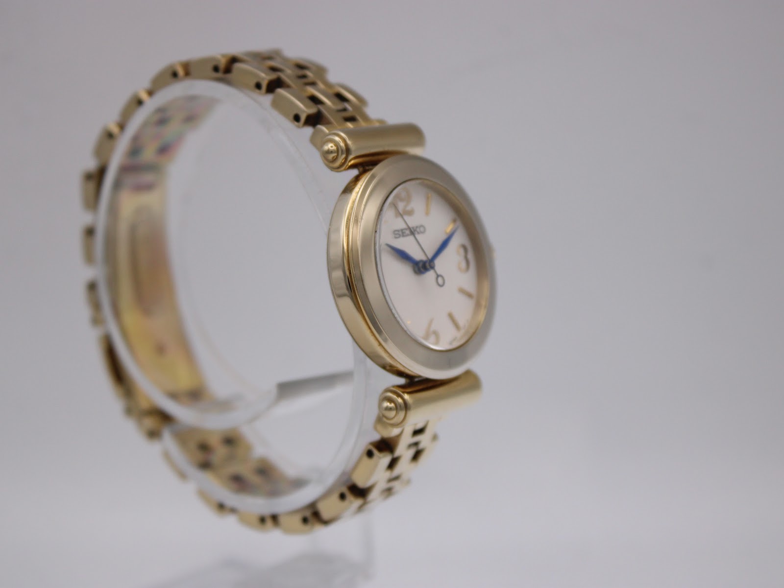 Close-up of the gold-tone integrated bracelet with the 'SEIKO' signed clasp.