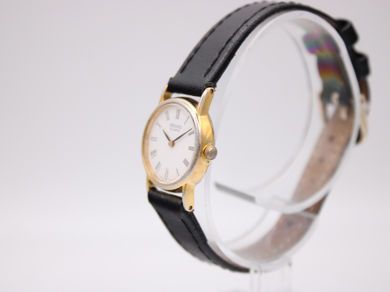 Angled side view of the vintage Seiko watch, highlighting the slender gold-plated case and crown.