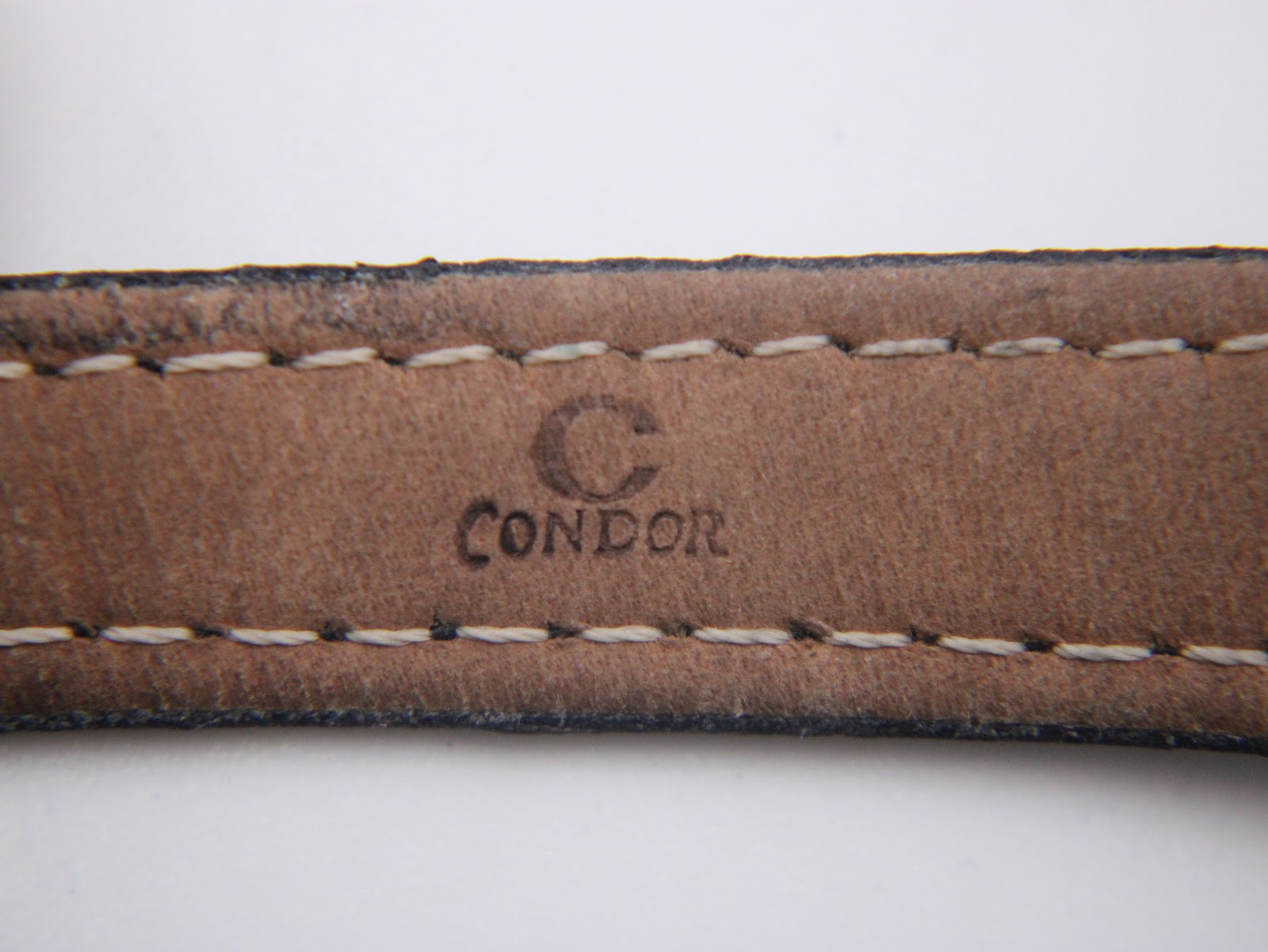 Detailed view of the black leather strap's underside, showing the 'Condor' brand stamp and stitching.