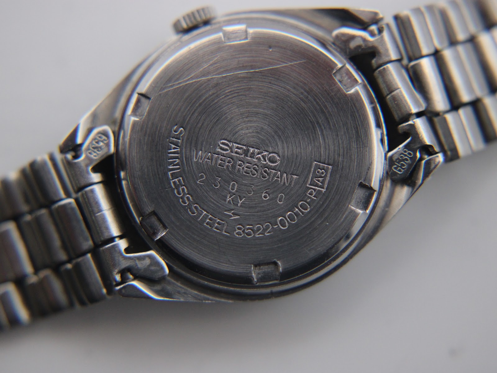 Detailed close-up of the silver sunburst dial with baton indices and date window.