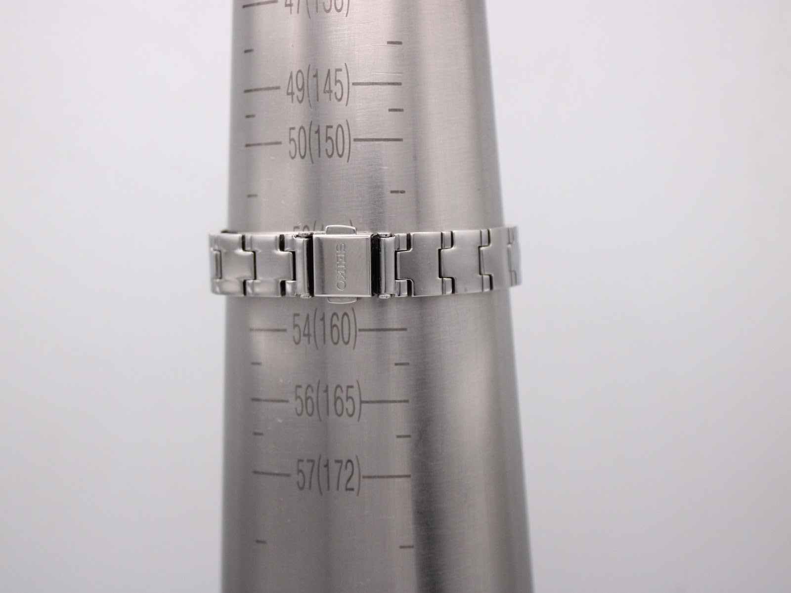 Close-up of the integrated stainless steel bracelet on a wrist sizing gauge, showing a circumference of 160mm.
