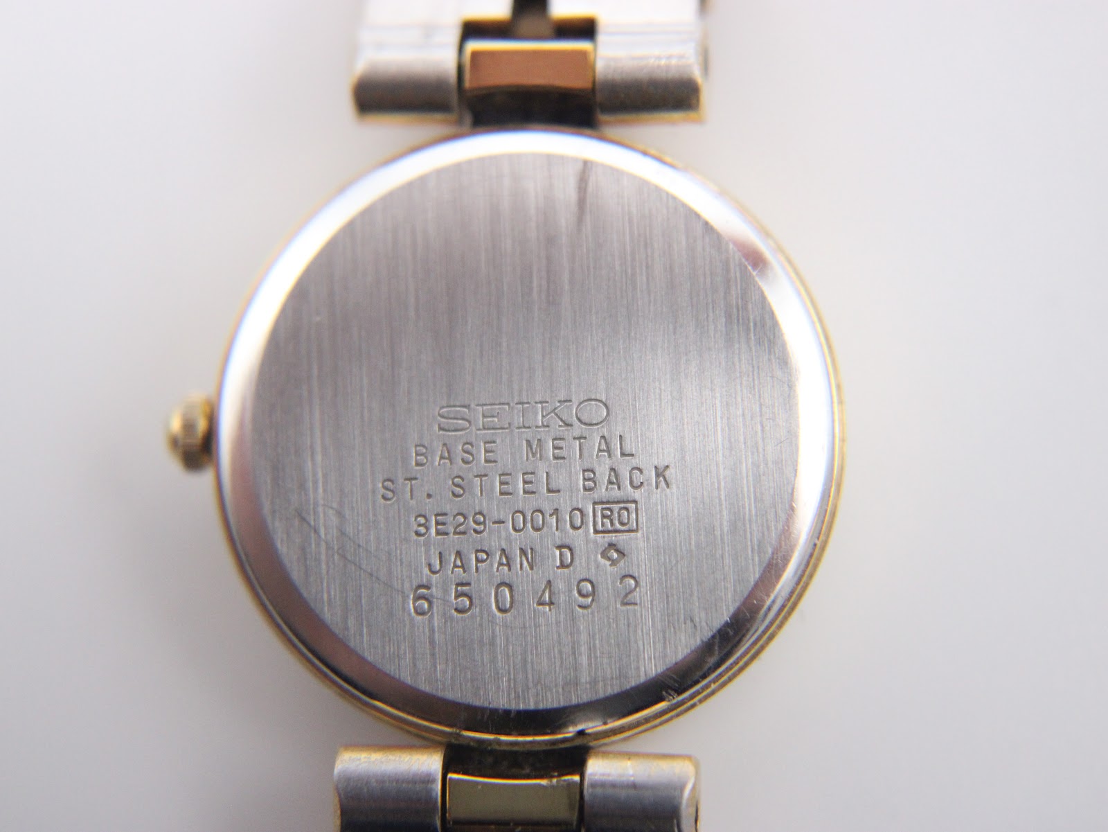 The gold Seiko watch being measured with digital callipers, showing a case diameter of 22.25mm.