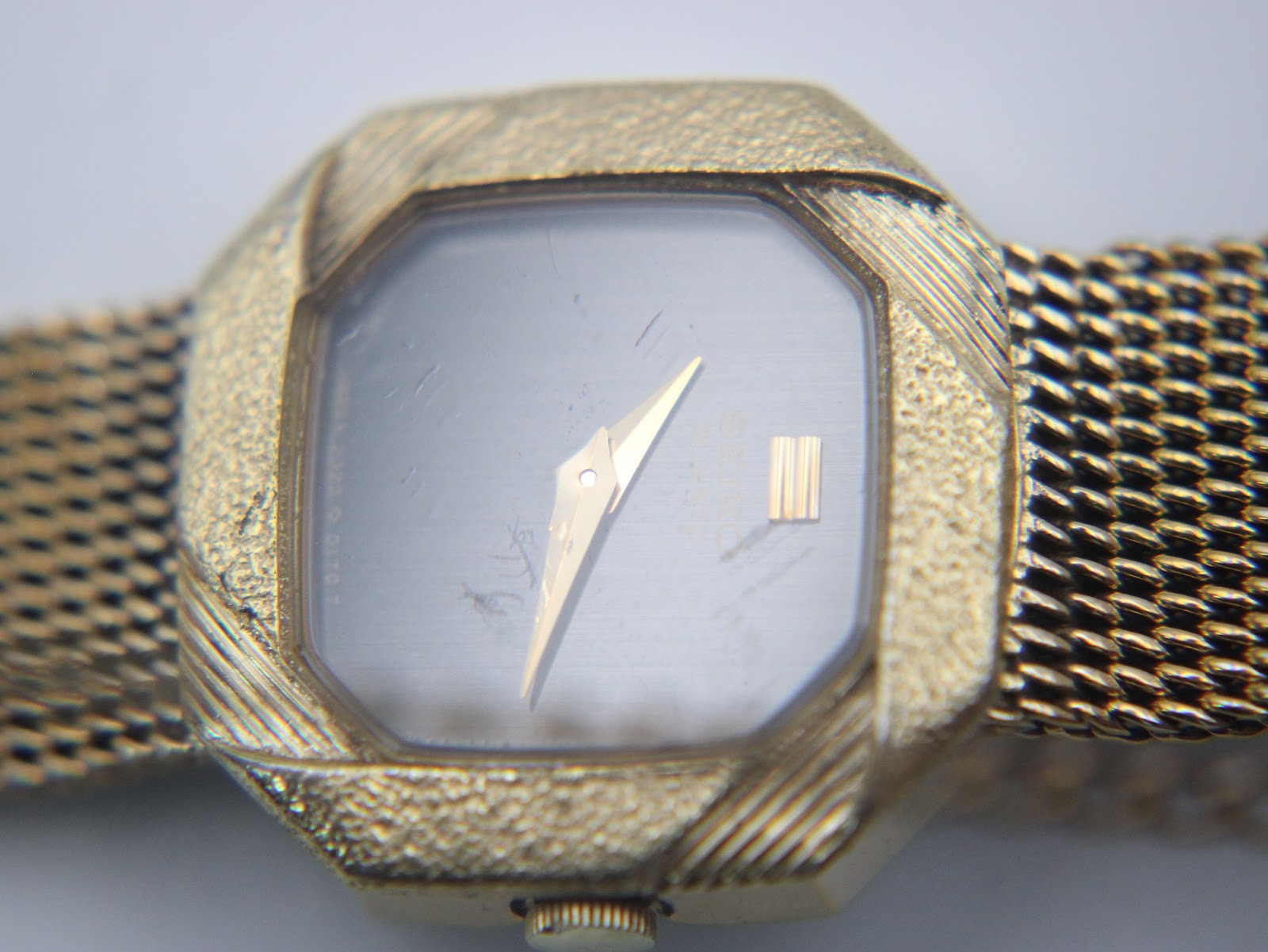 Macro shot of the black dial and gold hands of the Seiko 2320-5100 watch.