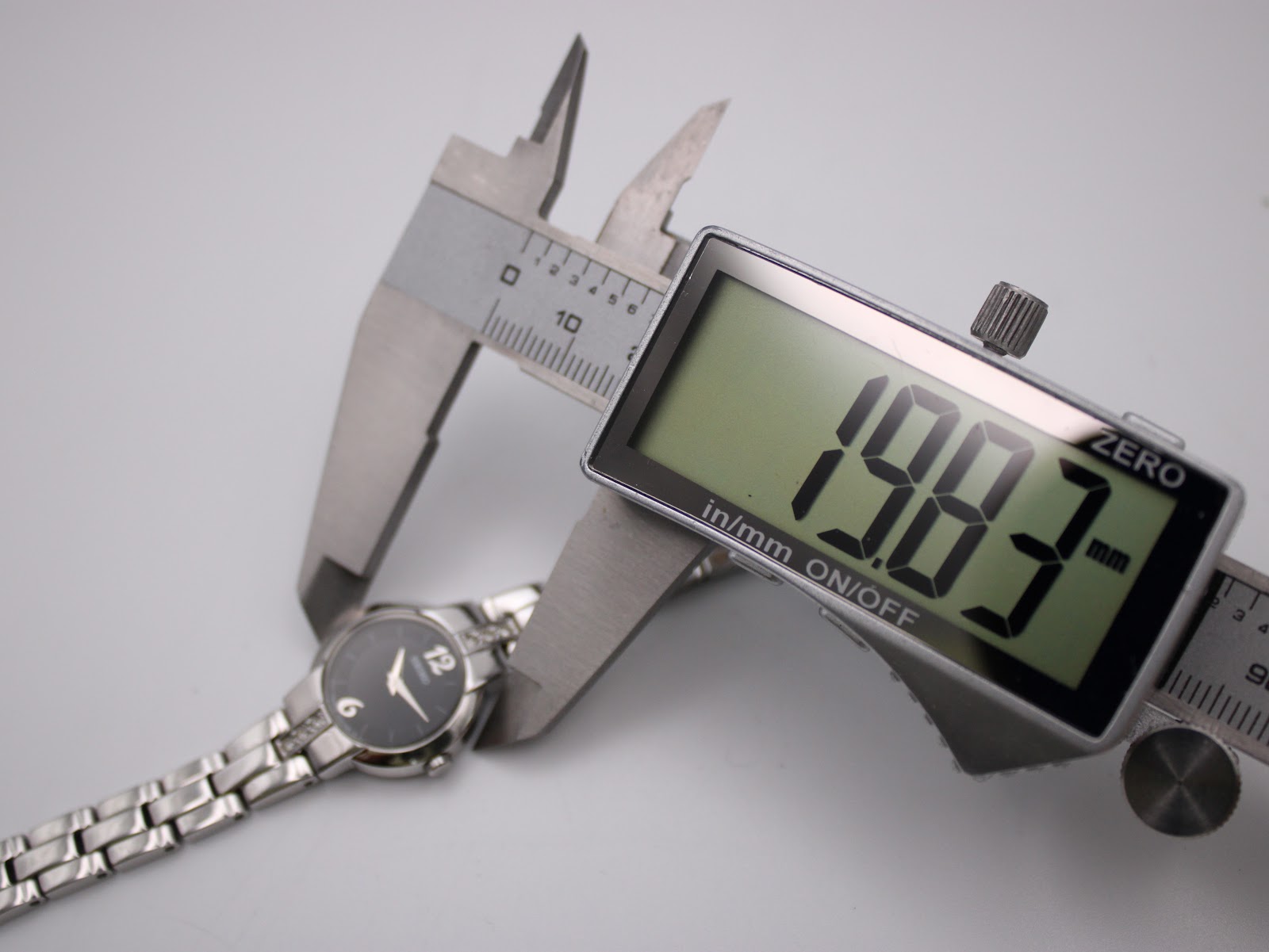 Digital caliper measuring the case diameter of the Seiko watch, showing 19.83mm.