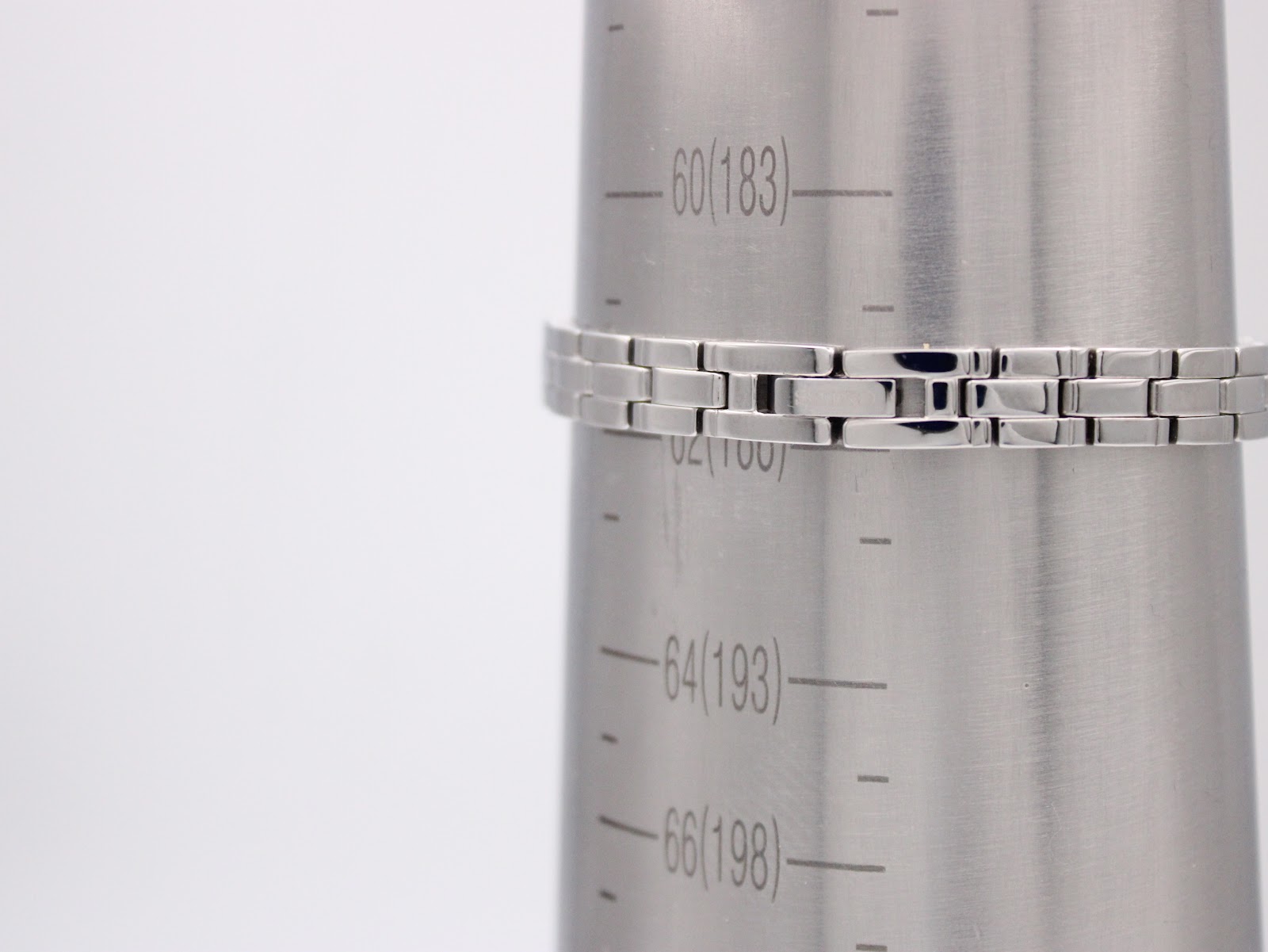 Close-up of the stainless steel bracelet on a wrist sizing cone, indicating a wrist circumference of approximately 186.5mm.