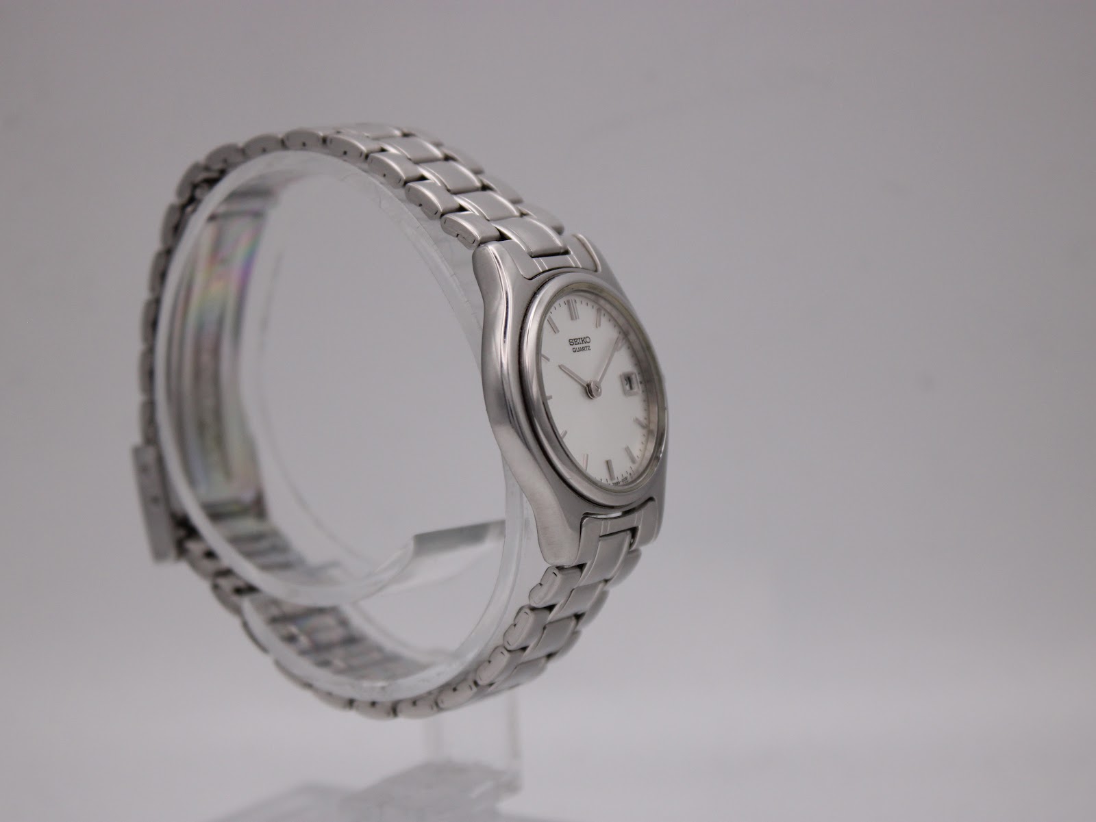 Close-up of the Seiko 7N89-0021 watch dial showing date window and baton markers.