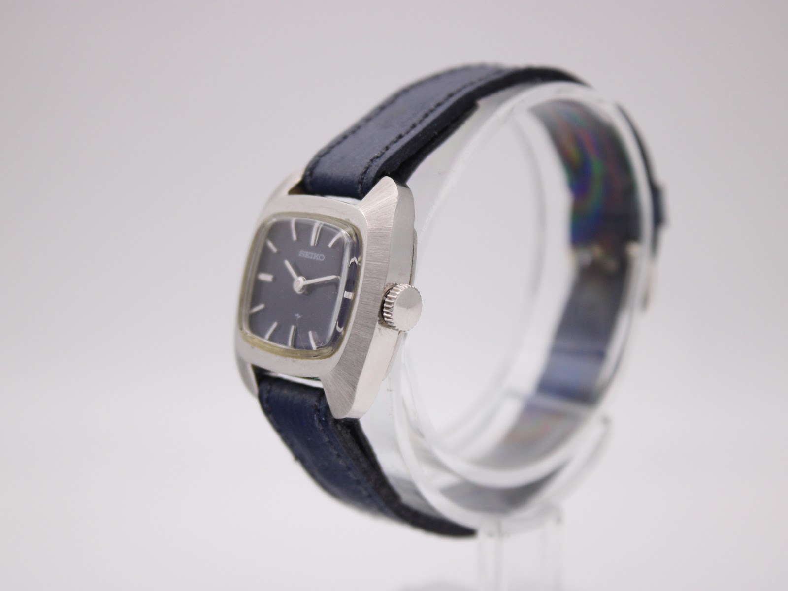 Side profile of Seiko ladies watch, showing brushed stainless steel cushion case and crown.