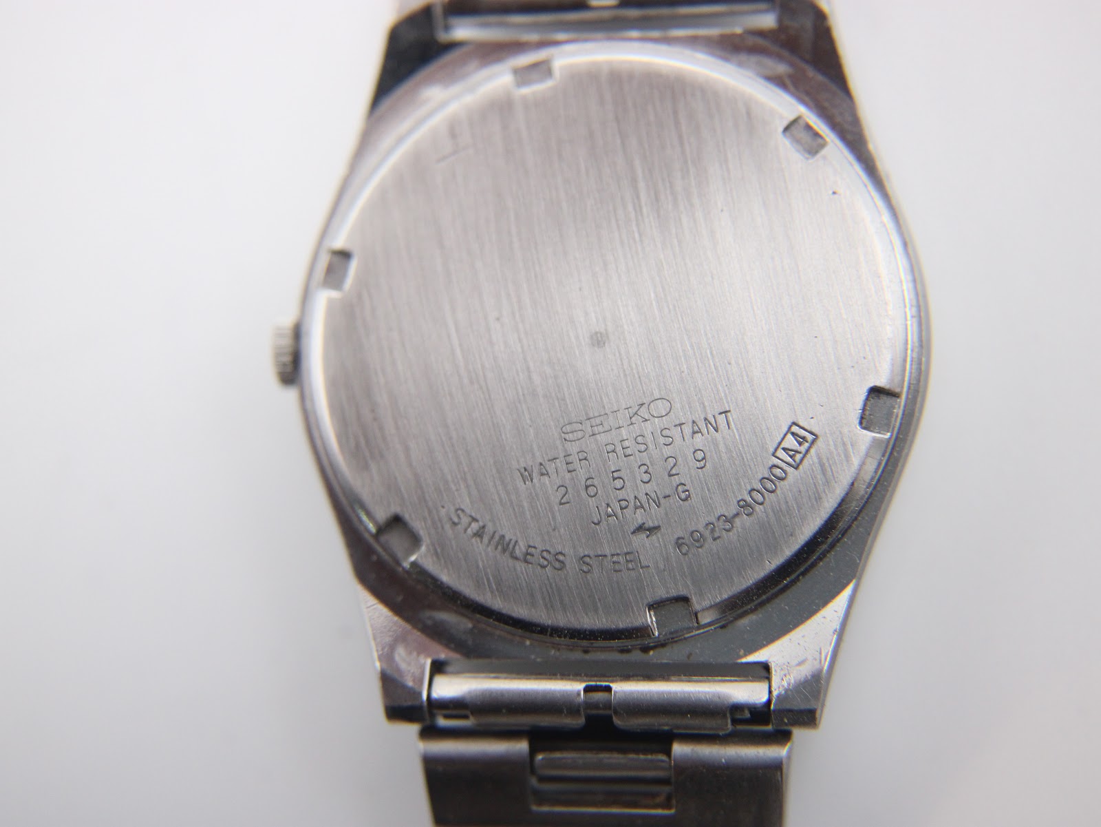 Detailed view of the dark blue dial with day-date window and "SQ" logo.