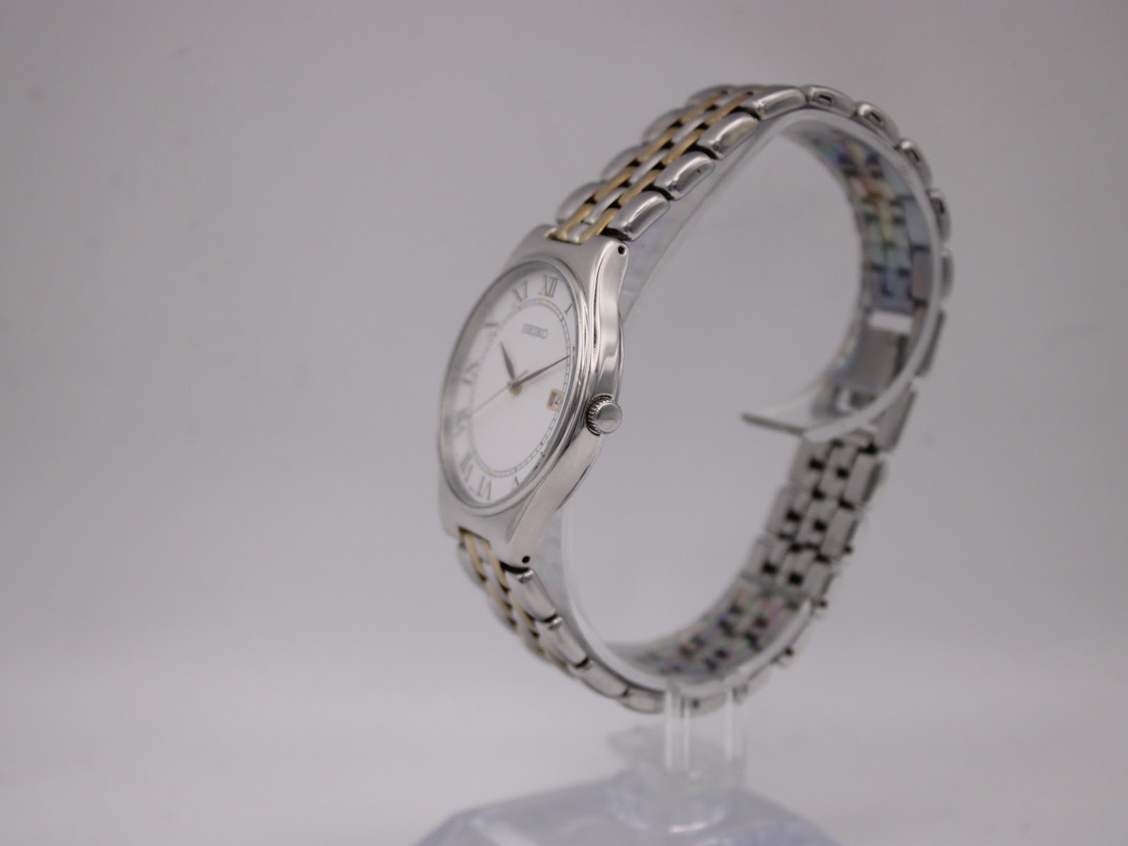 Side profile of the Seiko quartz watch showcasing its slim case and two-tone bracelet.