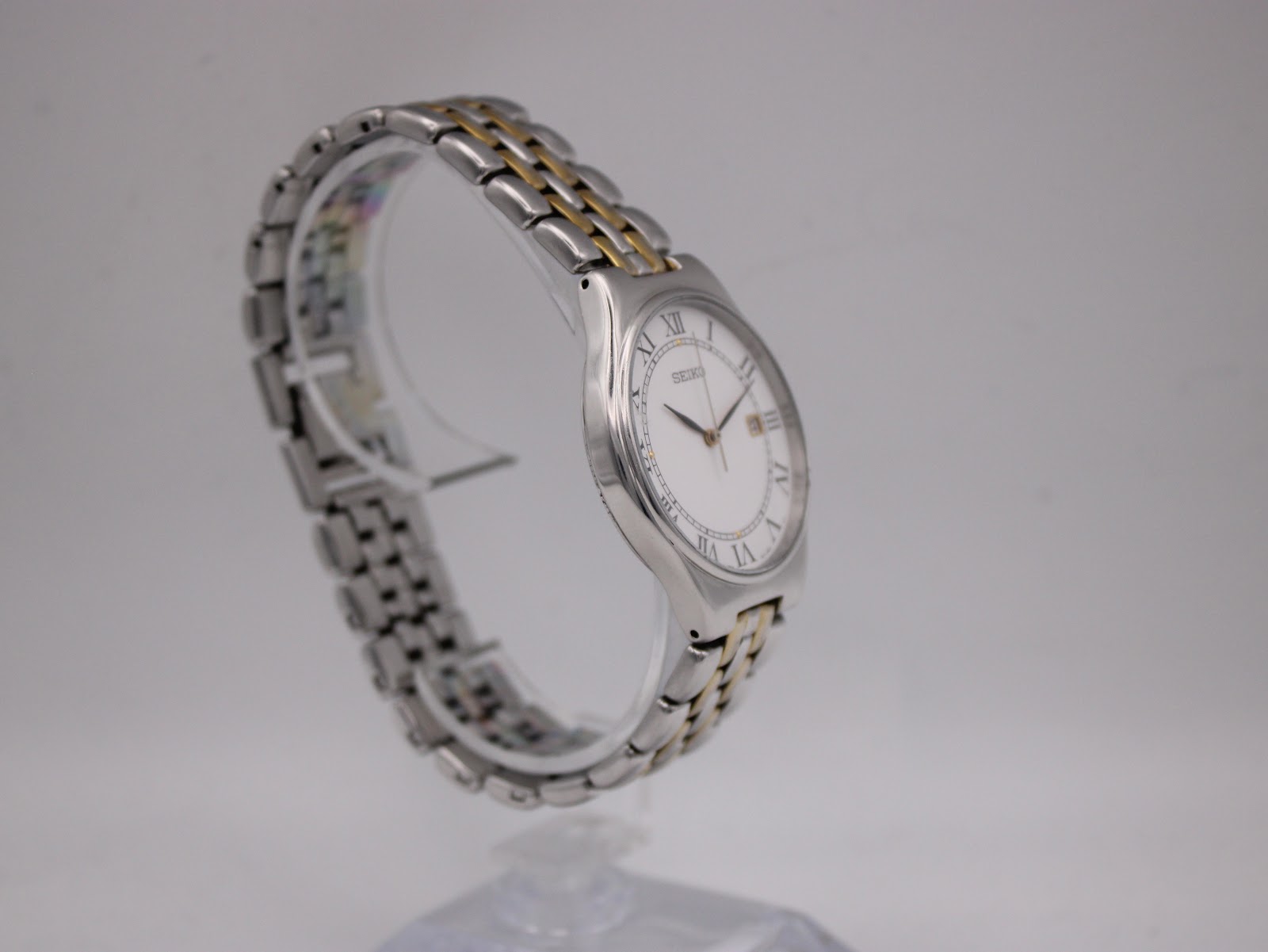 Close-up of the watch's two-tone stainless steel bracelet and signed Seiko butterfly clasp.