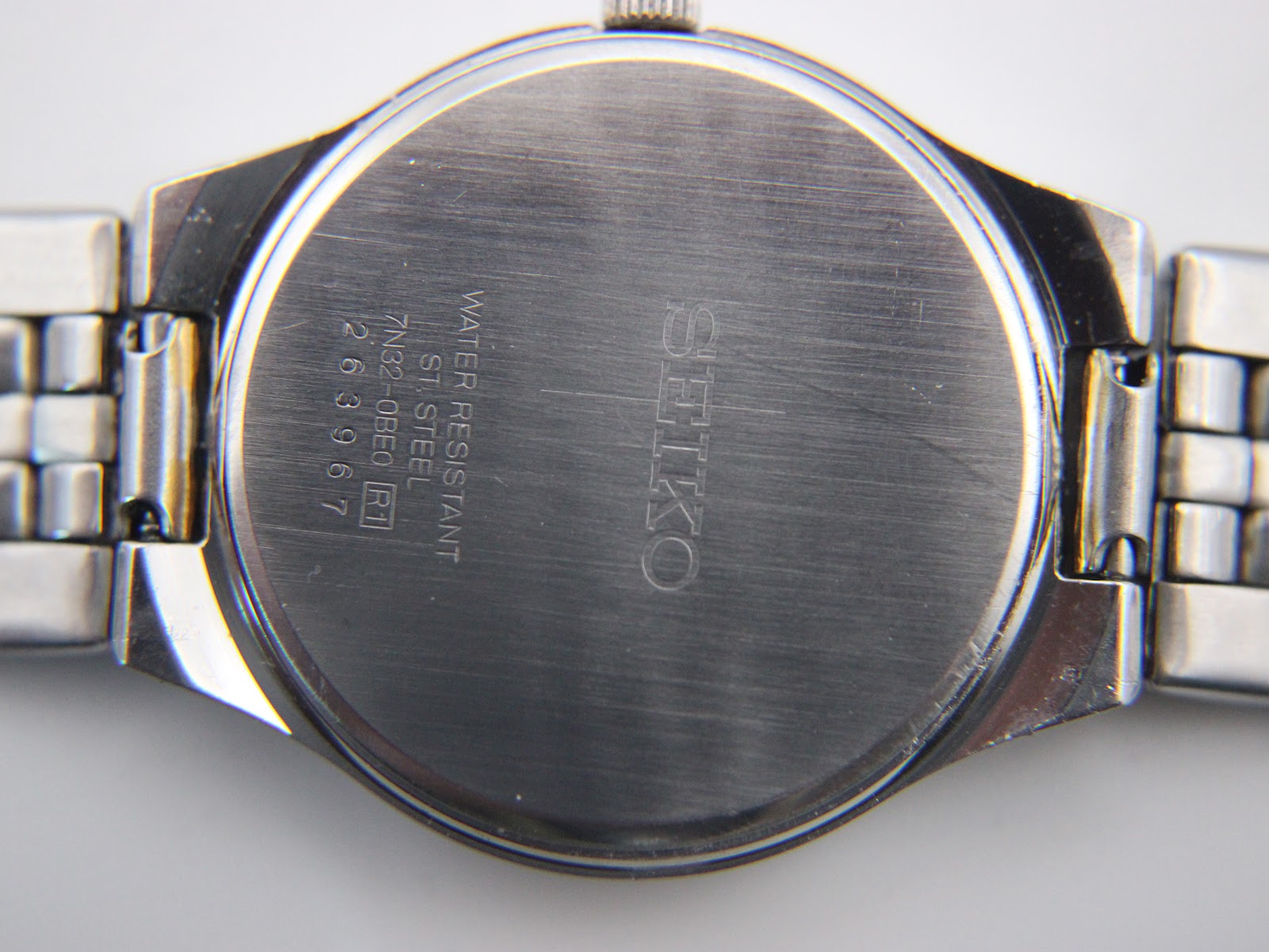 Detailed shot of the white dial with black Roman numerals, gold-tone hands, and date window.