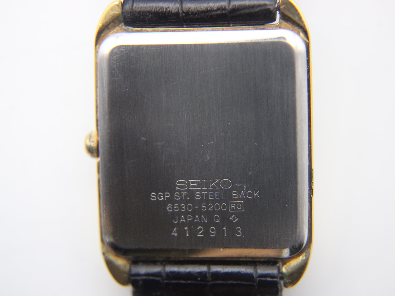 Detailed view of the white dial with Roman numerals and Seiko Quartz branding.