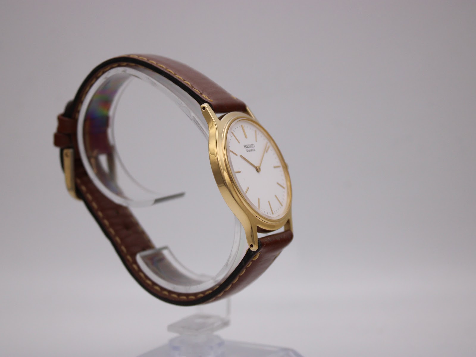 Close-up of the watch case back showing 'SEIKO BASE METAL ST. STEEL BACK V700-8A10' and serial number.