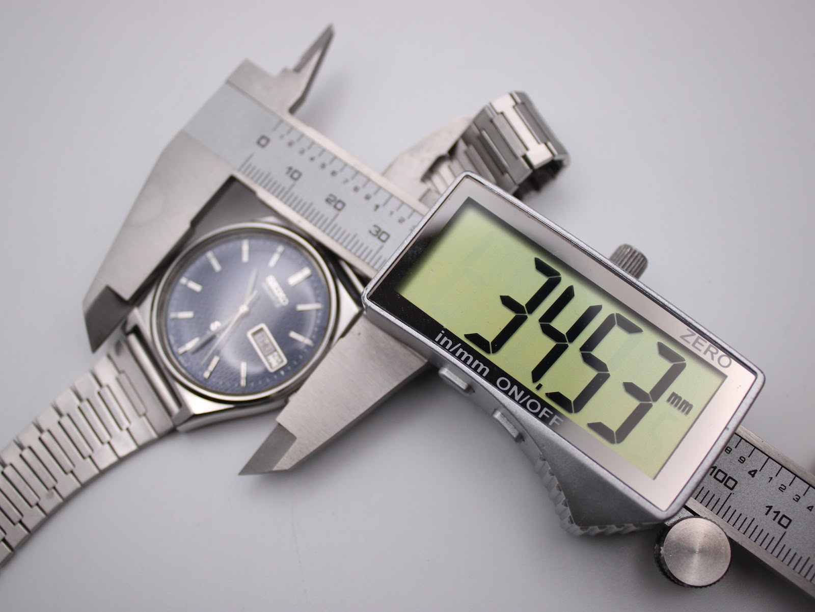 Digital caliper measuring the watch case diameter, clearly displaying a measurement of 34.53mm.