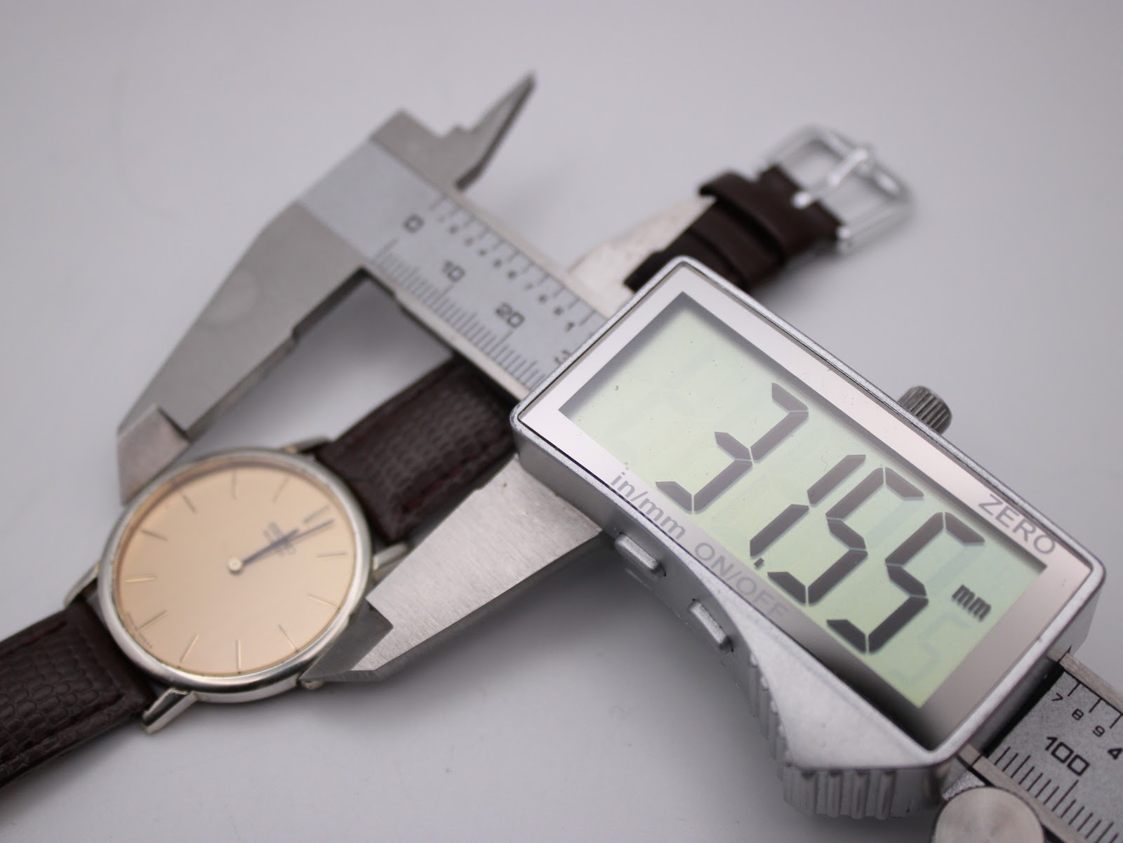 A digital caliper measuring the case diameter of the Seiko watch, displaying a precise measurement of 31.55mm.