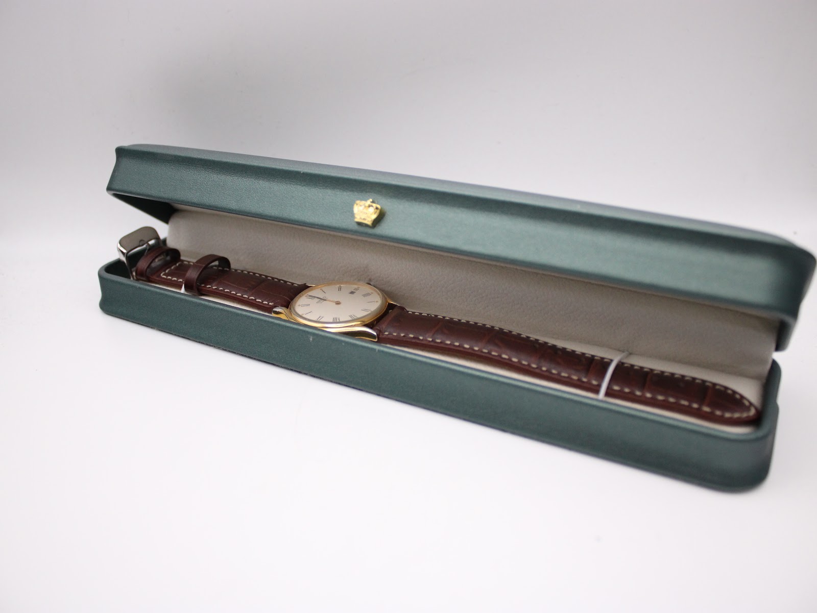 The Seiko watch presented in a generic dark green watch box with a gold crown emblem.