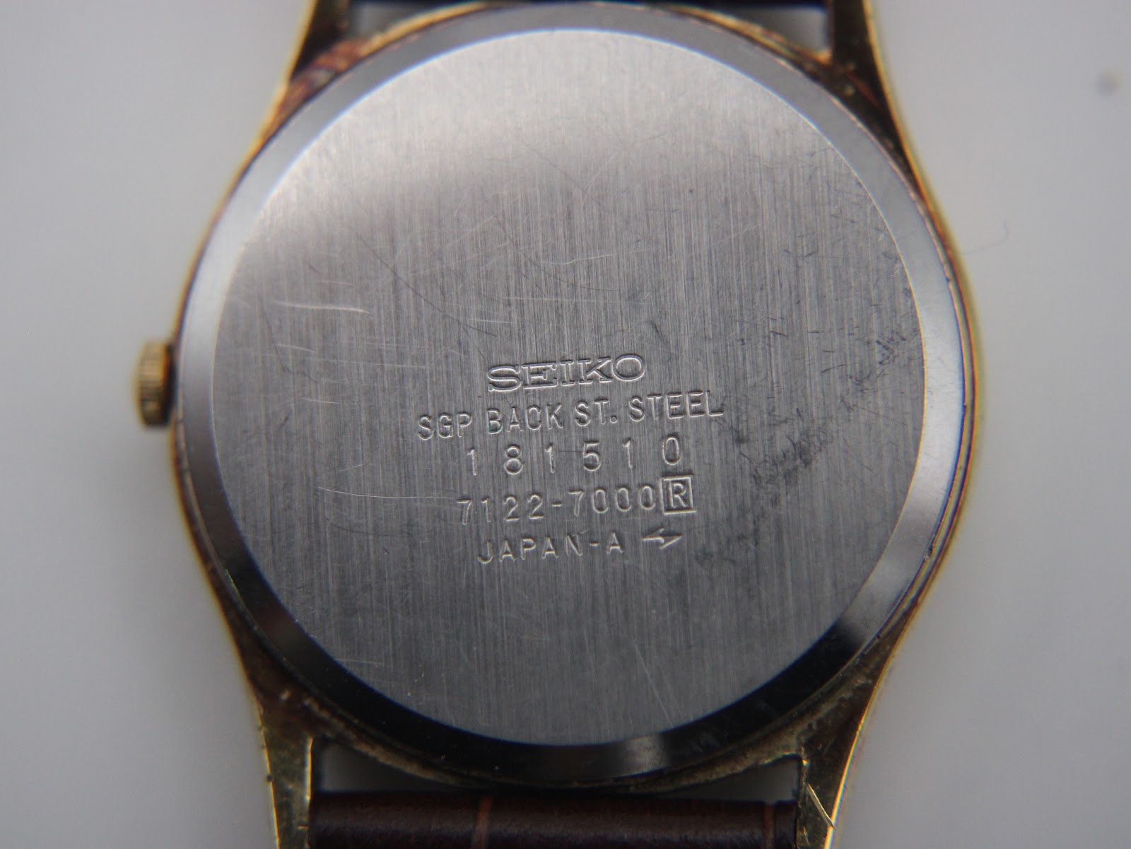 Close-up of the brushed stainless steel case back, clearly showing 'SEIKO SGP BACK ST. STEEL 181510 7122-7000 R JAPAN-A' engravings.