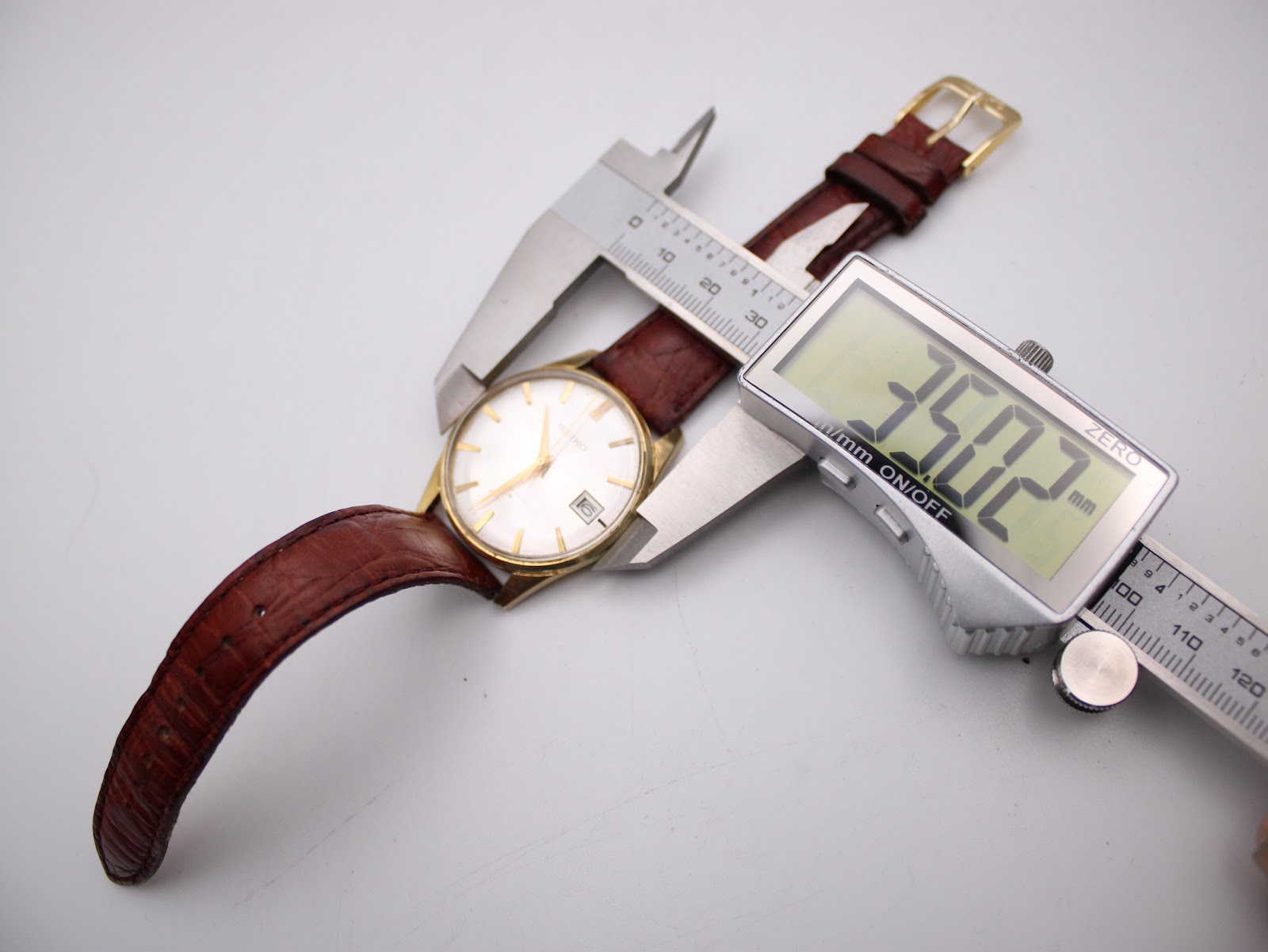 Digital caliper measuring the case diameter of the Seiko watch, showing 35.02mm.