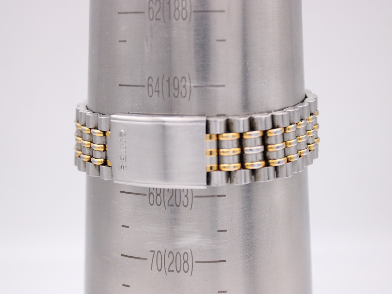 Close-up of the two-tone stainless steel bracelet with signed Seiko clasp on a wrist sizing gauge, indicating a maximum wrist size of approximately 20cm.
