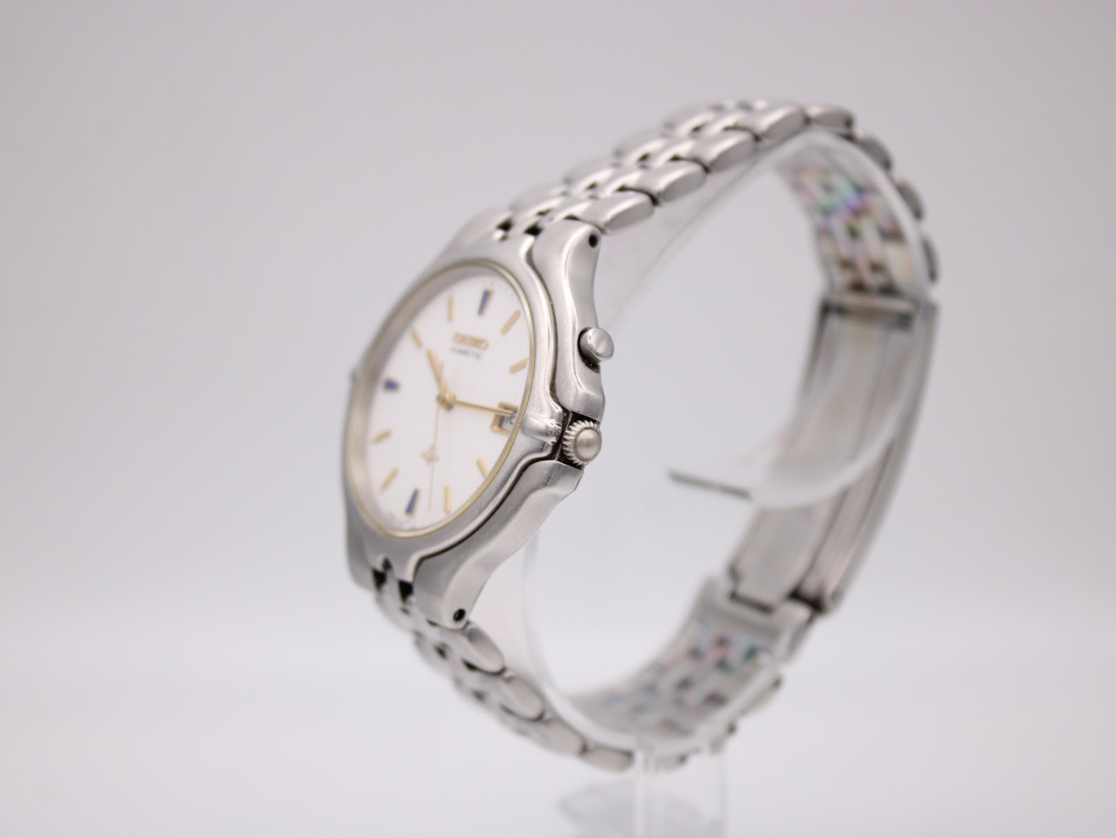 Side view of Seiko Kinetic watch on a stand, showing the case profile and integrated bracelet.
