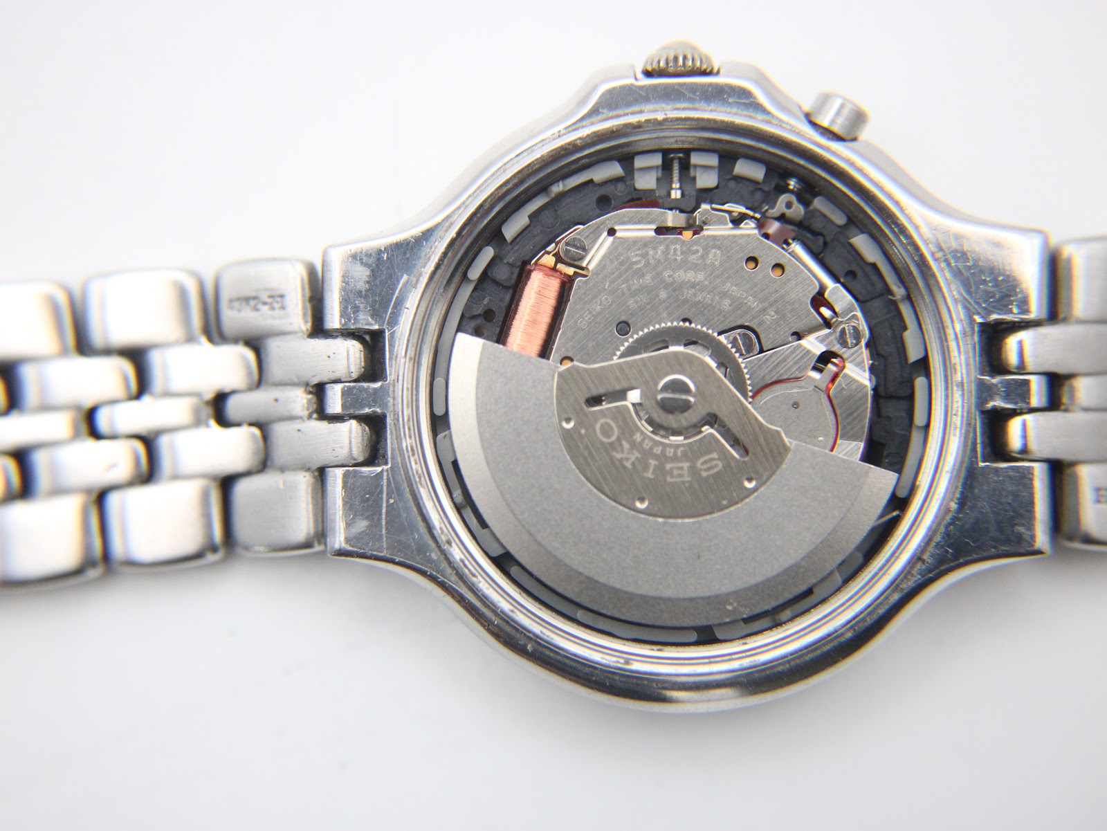 Close-up of the Seiko 5M42A kinetic movement visible through an open case back.