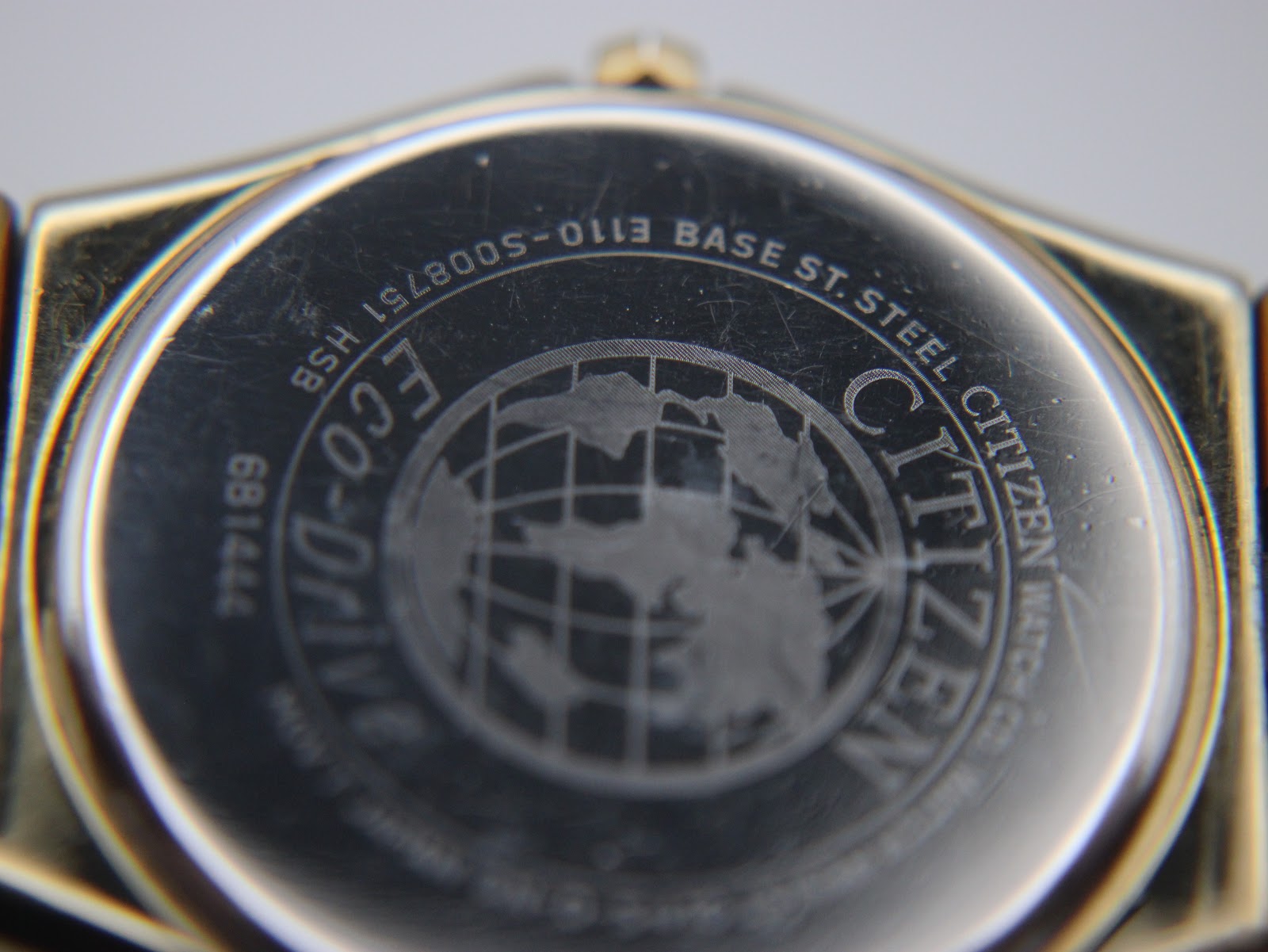 Detailed close-up of the Citizen Eco-Drive watch case back, showing 'S008751 HSB' and 'Citizen Watch Co.'.