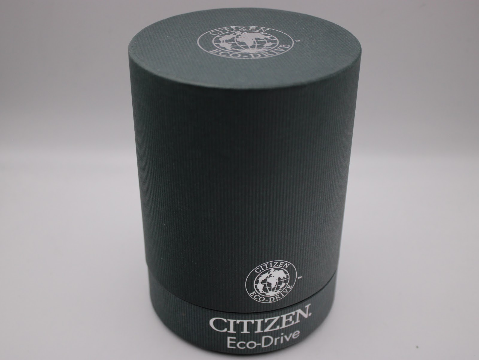 The closed original cylindrical grey box for the Citizen Eco-Drive watch.