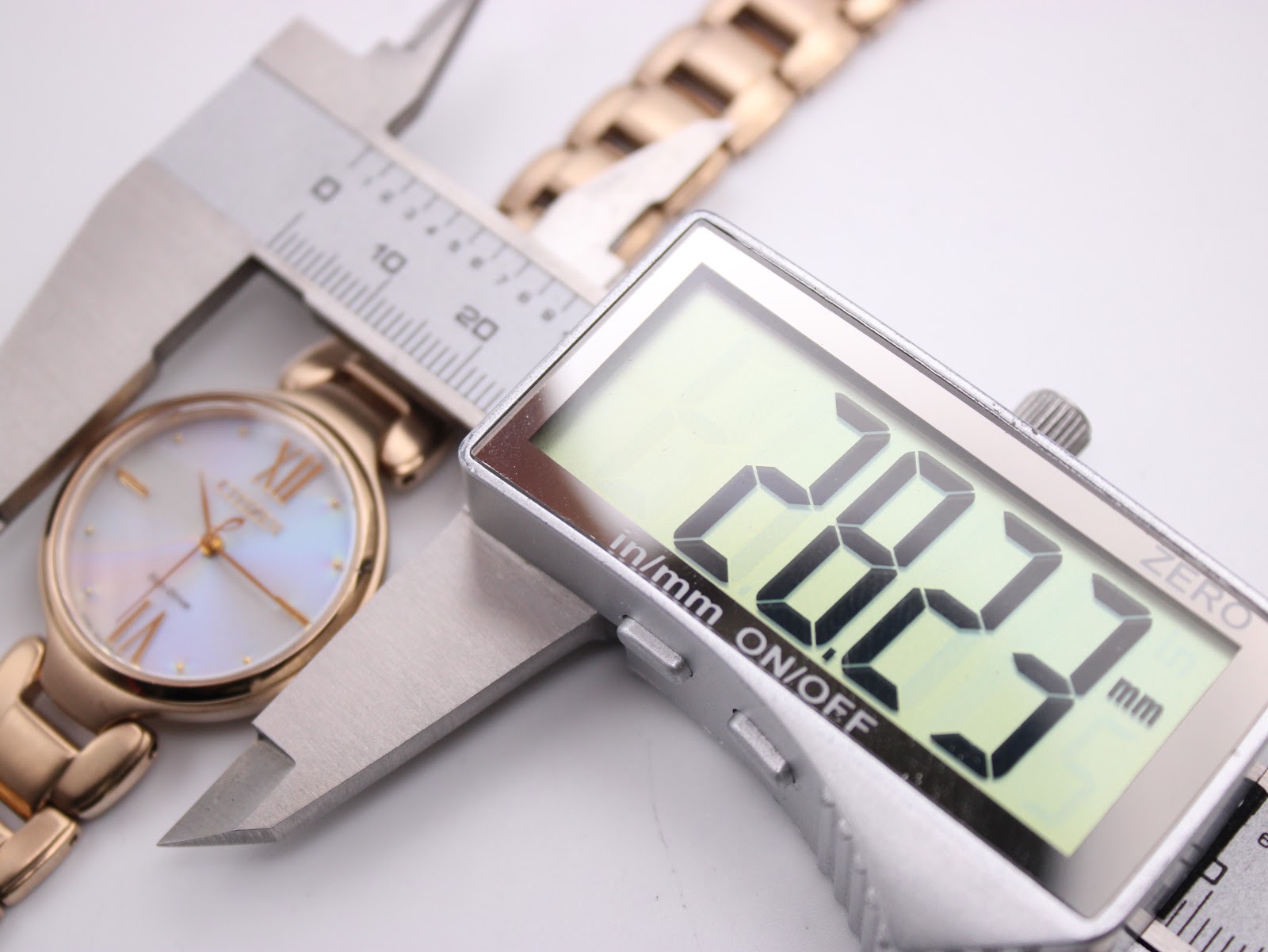 A digital caliper measuring the case diameter of the Citizen Eco-Drive watch, displaying 28.3mm.