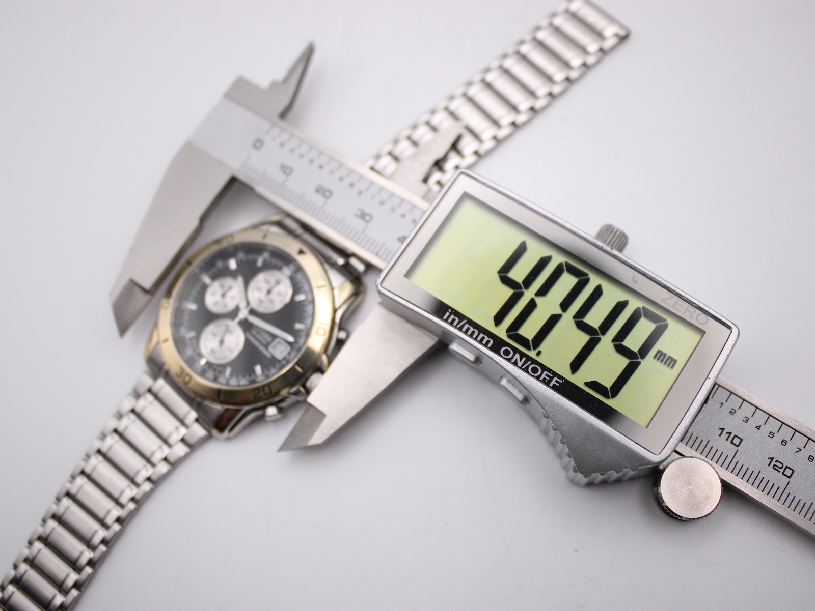Digital caliper measuring the case diameter of the Citizen watch, showing 40.49mm on the display.