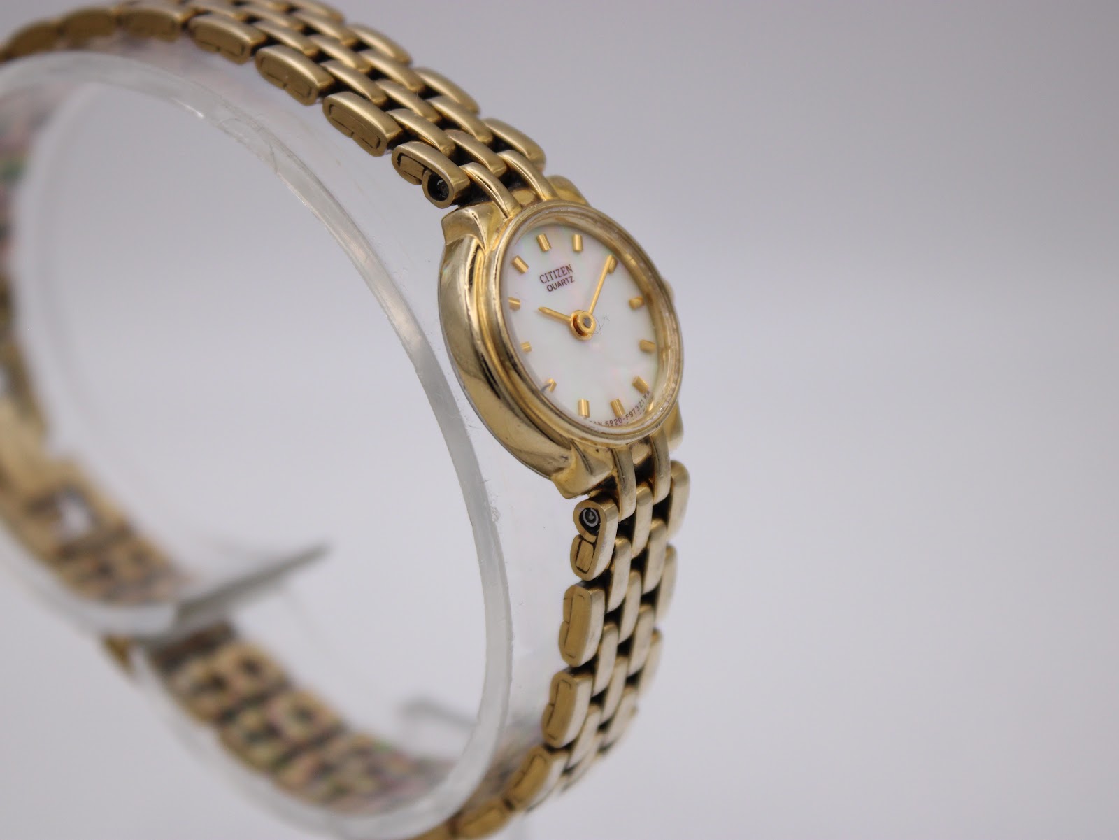 Side-on view of the gold tone Citizen ladies watch, highlighting the iridescent mother of pearl dial.